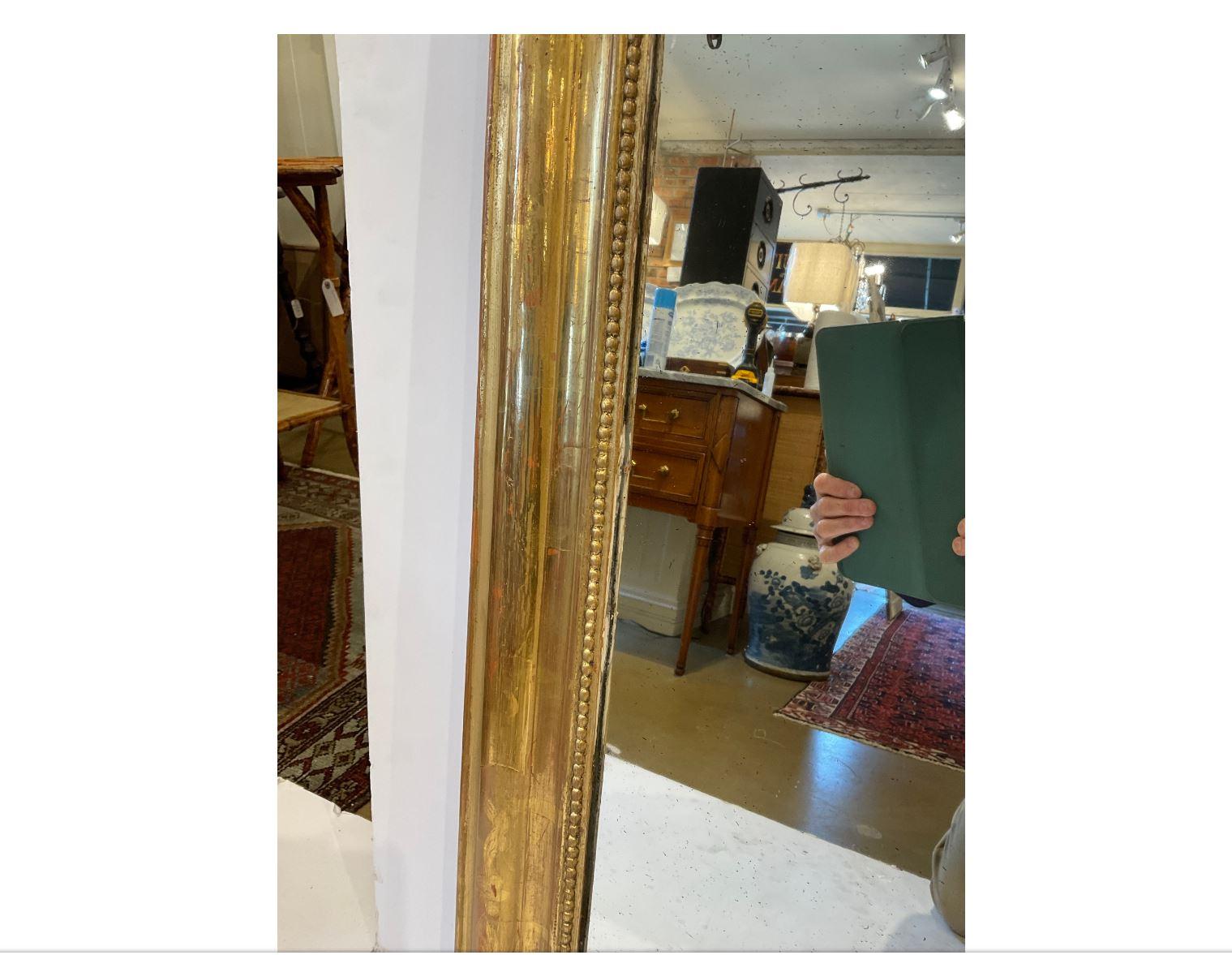 This is a gorgeous 19th Century Louis Philippe mirror. The mirror has a beautiful gold beaded design on the inner border, as well as intricate hand carved floral designing on the outside edges. This would make a wonderful addition to any room!