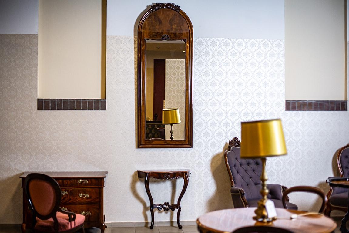 Un miroir haut dans un cadre en bois ainsi qu'une table console.
L'ensemble est de style Louis Philippe et a été fabriqué dans la seconde moitié du XIXe siècle.
Le cadre est surmonté d'un arc avec une modeste application.
La table console est