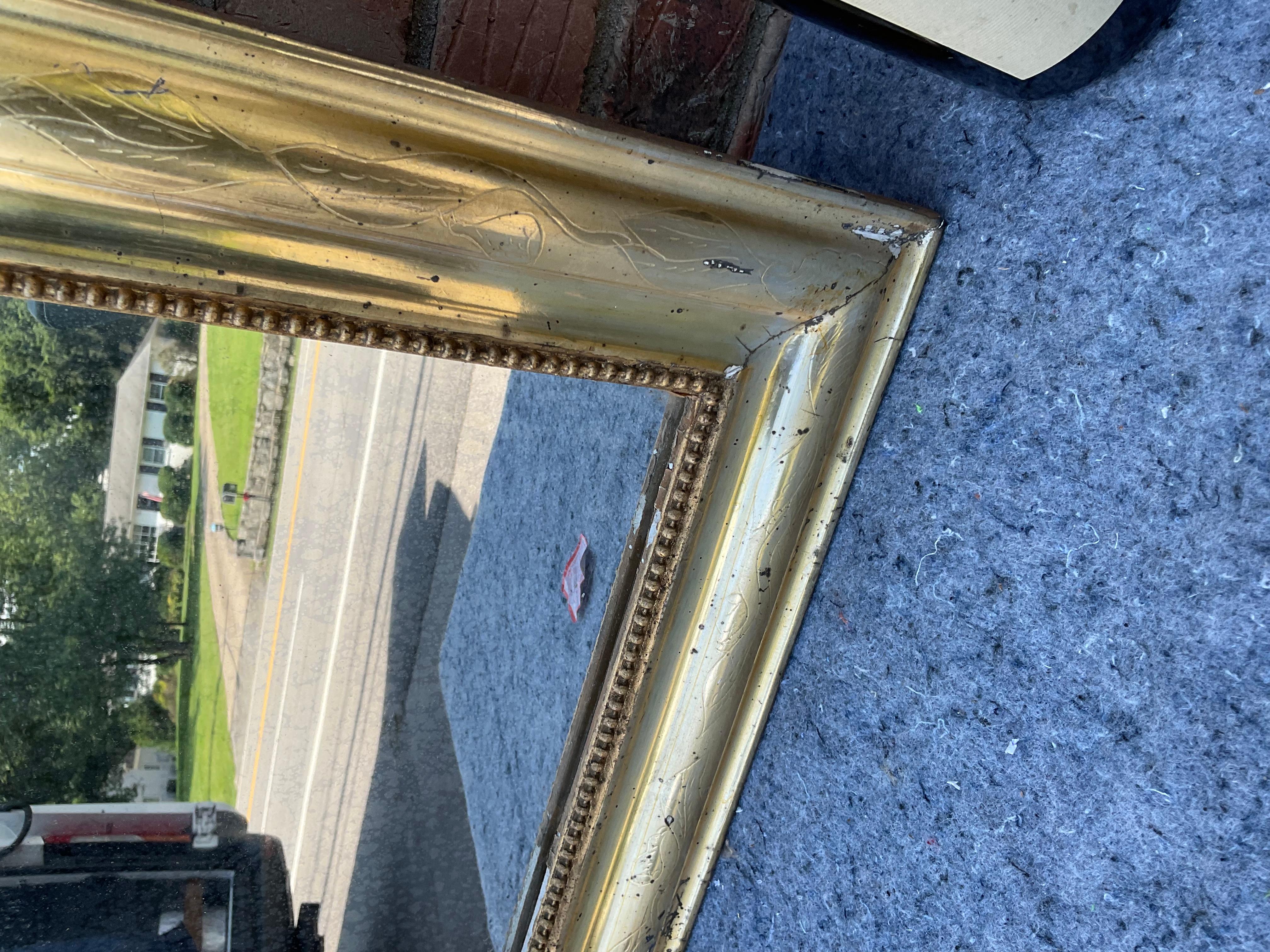 This 19th century Louis Philippe mirror is truly unique! This mirror's tiny size makes this mirror an especially rare find. There is beautiful aging on this piece with the finish starting to wear away in places revealing the undertone. Solid and in