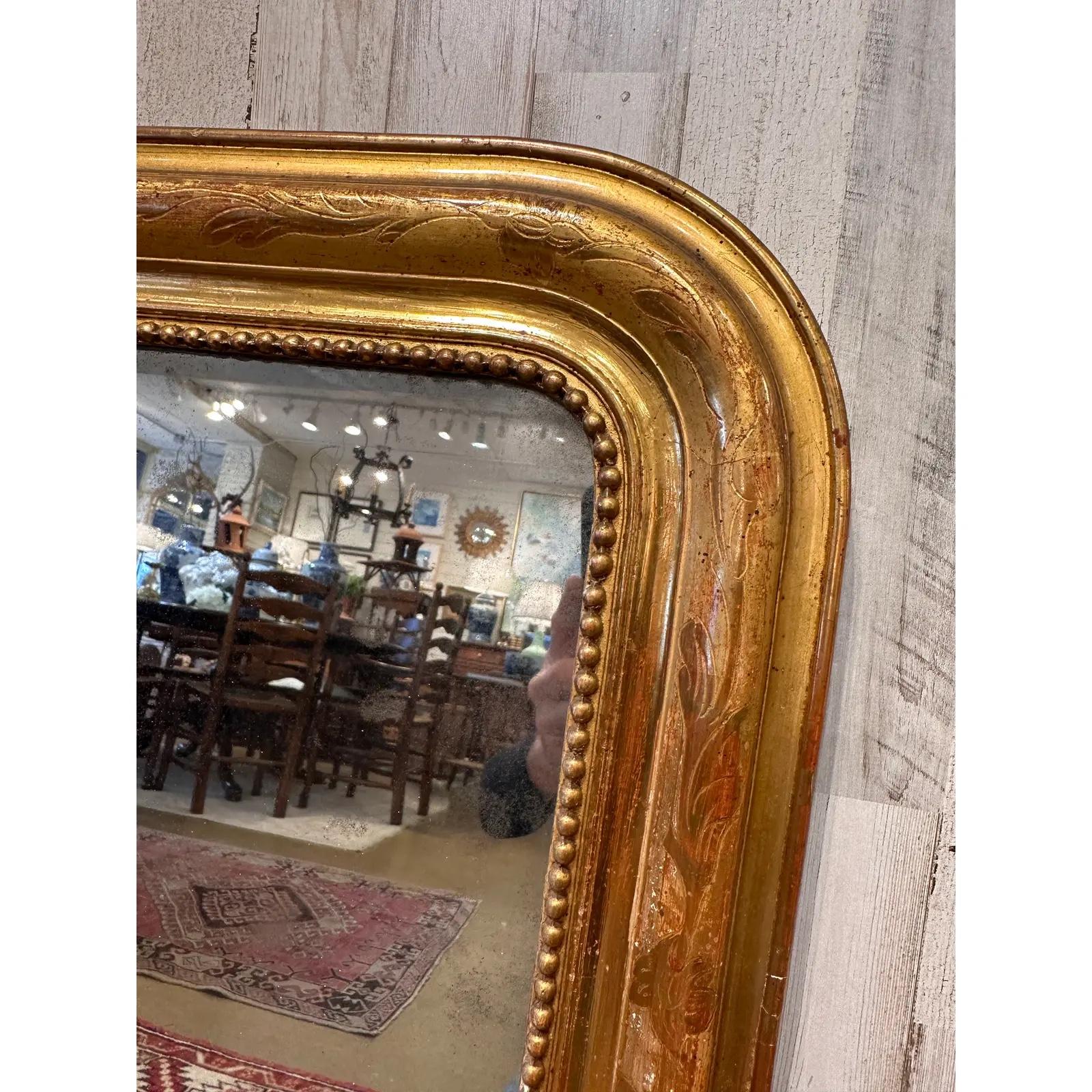 his exquisite Antique Louis Philippe Mirror, adorned with a gilded finish, effortlessly brings timeless charm to any space. Its ornate detailing and classic design make it a captivating centerpiece, reflecting both style and history in a single