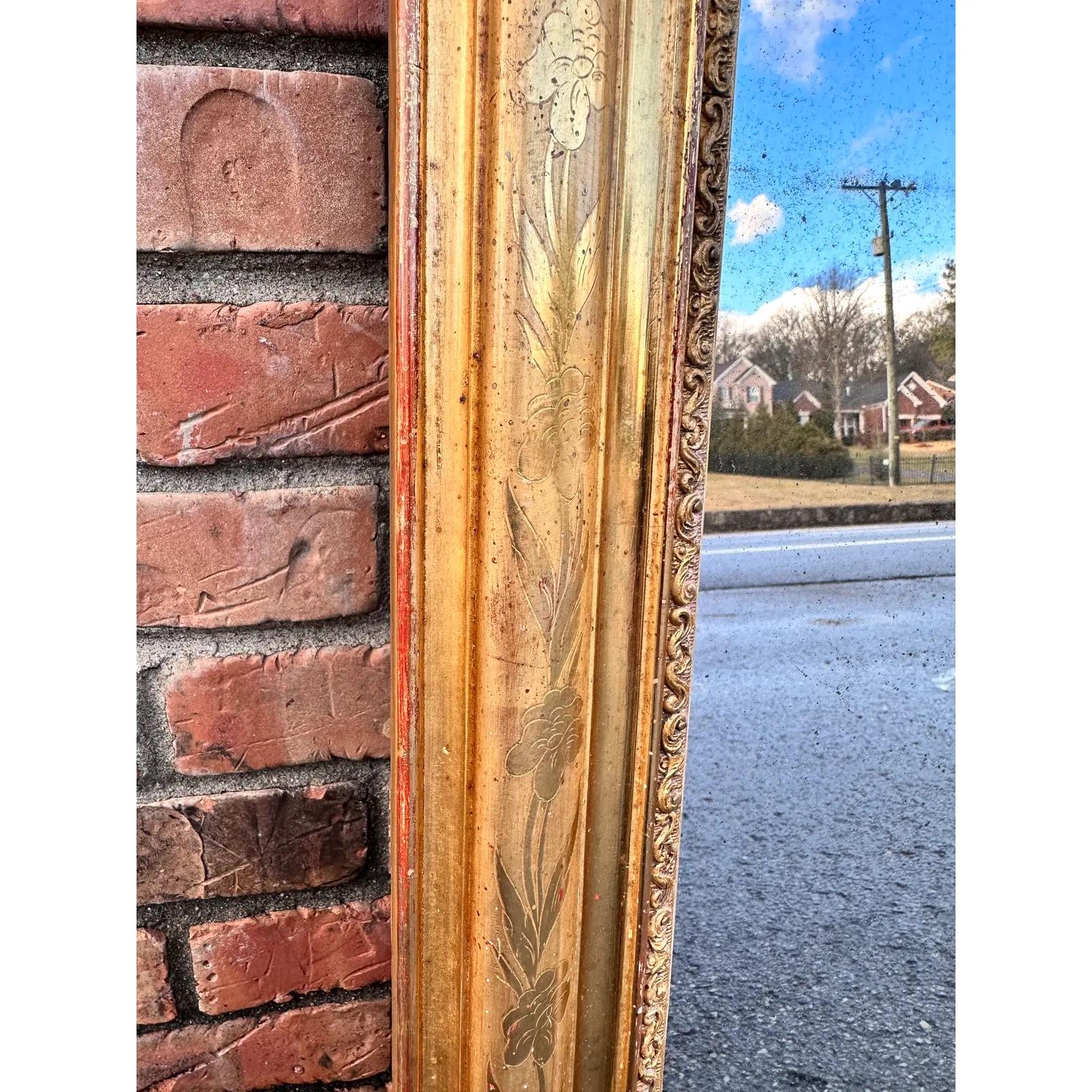 This is a beautiful 19th century French Louis Philippe Mirror. The outer border features a lovely floral leaf pattern, while the inner border is a delicate ornamental hand carved scroll pattern. The gold is beginning to fade away in places revealing