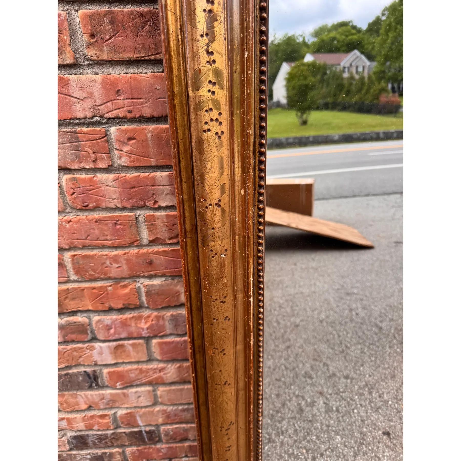 This is a gorgeous 19th Century Louis Philippe mirror! The mirror features a beautiful gold bead design on the inner border, with a hand carved floral pattern on the outer edges. The gold gilt is wearing away in some places, which is a good