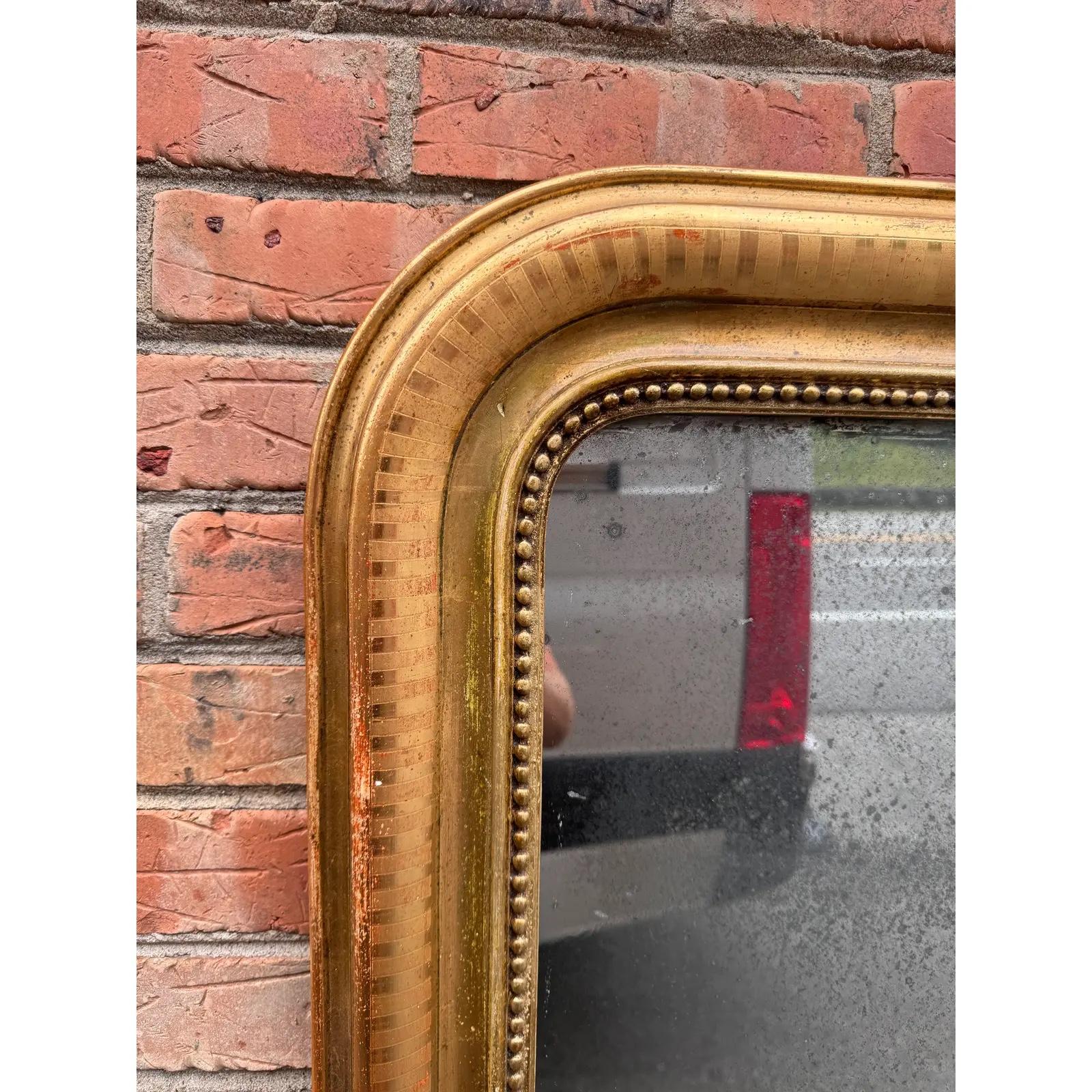 Questo è uno splendido specchio Louis Philippe del XIX secolo! Lo specchio presenta un bellissimo disegno di perline dorate sul bordo interno e un motivo intagliato a mano sui bordi esterni. La doratura si sta consumando in alcuni punti, il che è un