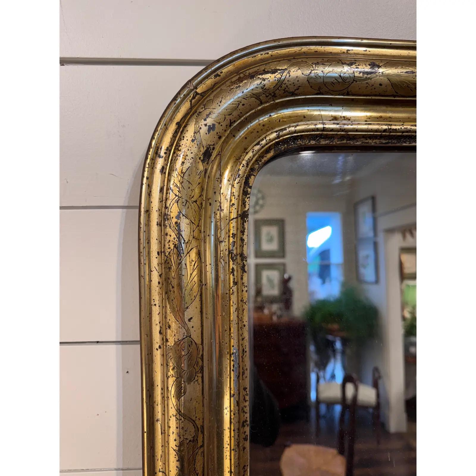 Il s'agit d'un magnifique miroir Louis Philippe du 19ème siècle ! Le miroir présente un magnifique motif floral champagne gravé le long de la bordure. La dorure s'use par endroits, ce qui est un bon indicateur de la vieillesse du miroir. Cette