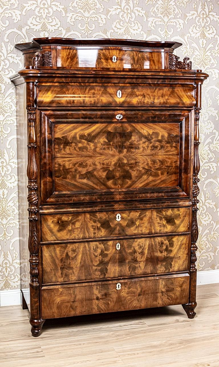 We present you a Louis Philippe secretaire from the mid-19th century.
There are three bottom drawers, a removable board flush with the rest, and a narrow drawer with a concave-convex front under the cornice.
The whole is finished with a flat,