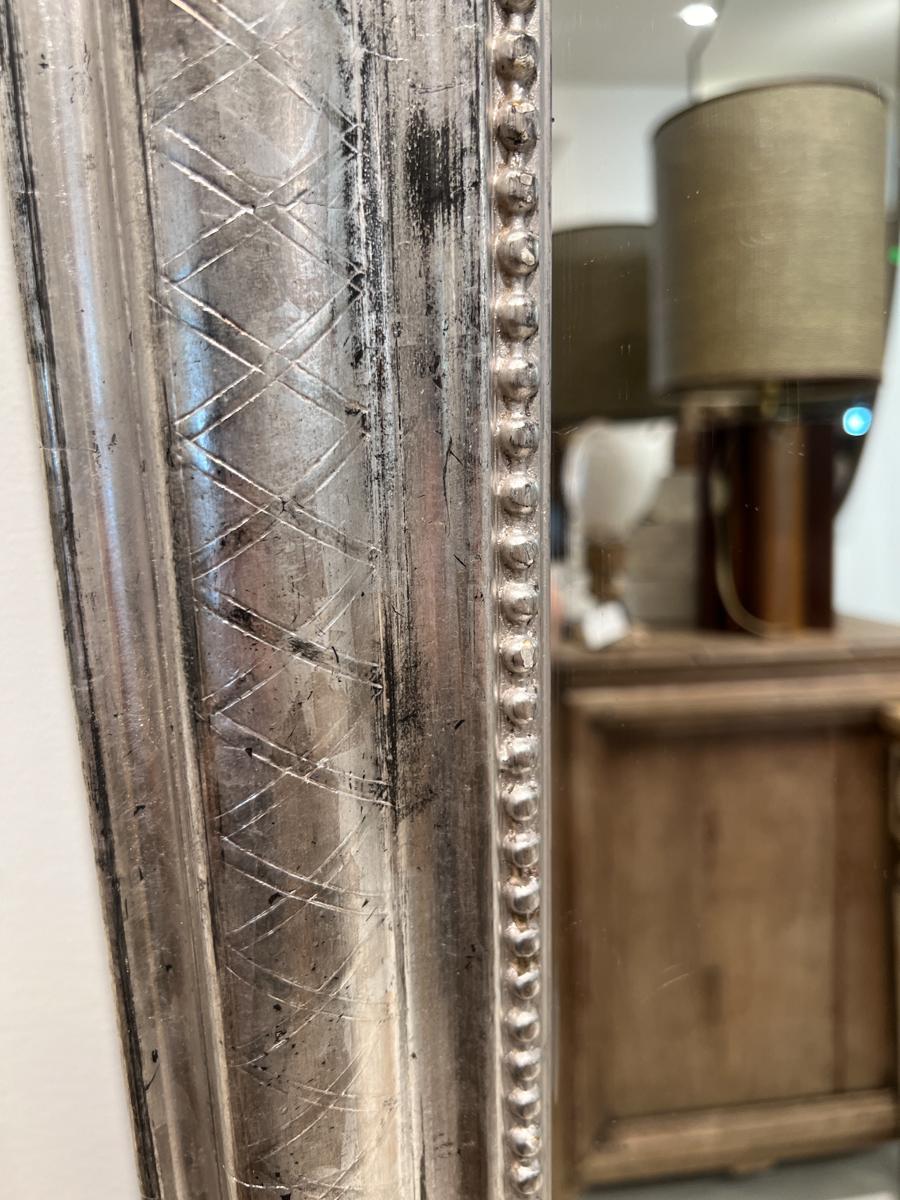 Immergiti nella raffinata eleganza dell'arredamento francese del XIX secolo con questo squisito specchio a foglia d'argento Louis Philippe del XIX secolo. Questo specchio incarna la sobria raffinatezza e il fascino senza tempo caratteristici del