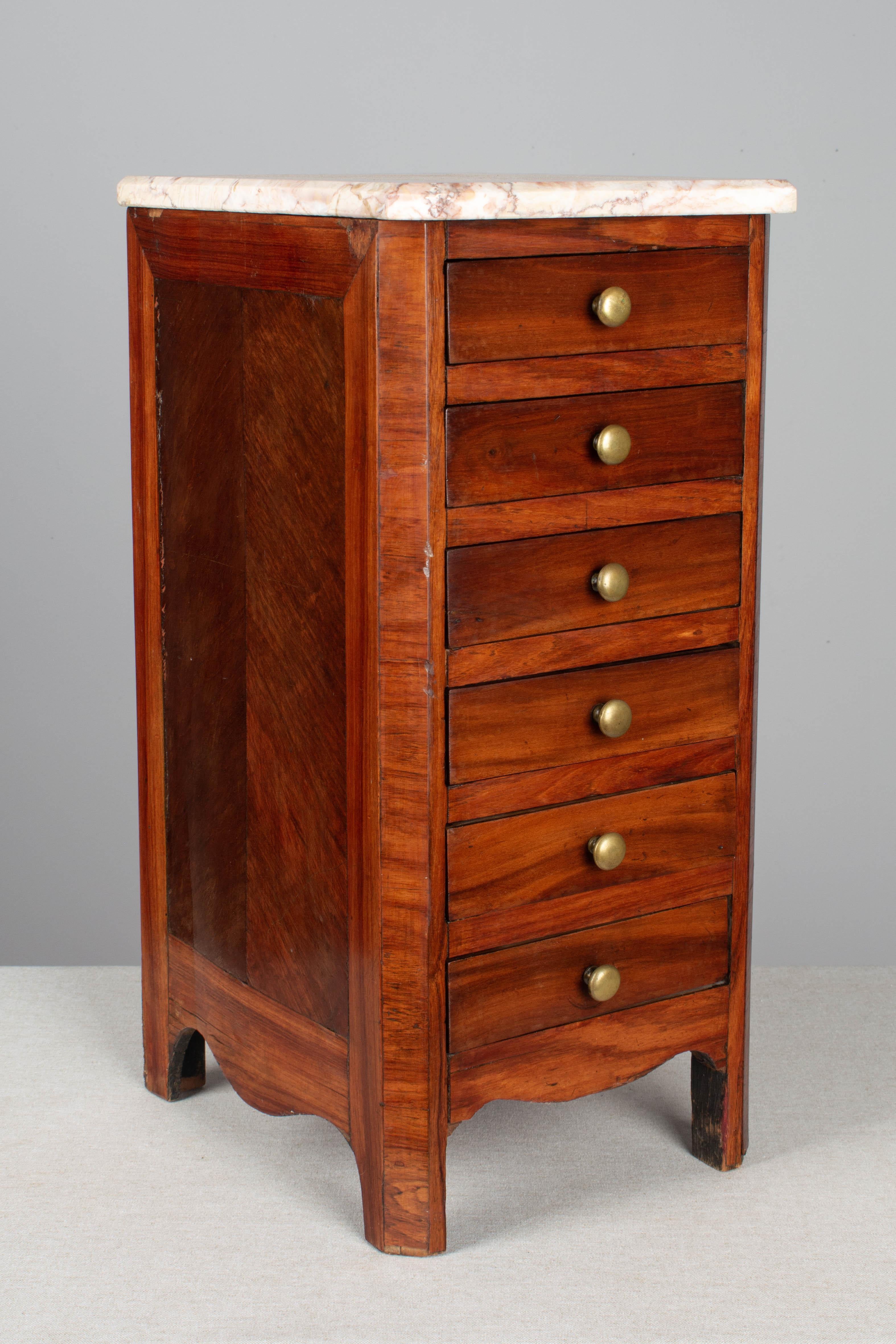 A 19th century Louis Philippe style miniature sample commode made of solid and veneer of mahogany with French polish finish. Five dovetailed drawers with brass knobs. Unusual tall, deep proportions. Replaced marble top is not attached. Minor veneer