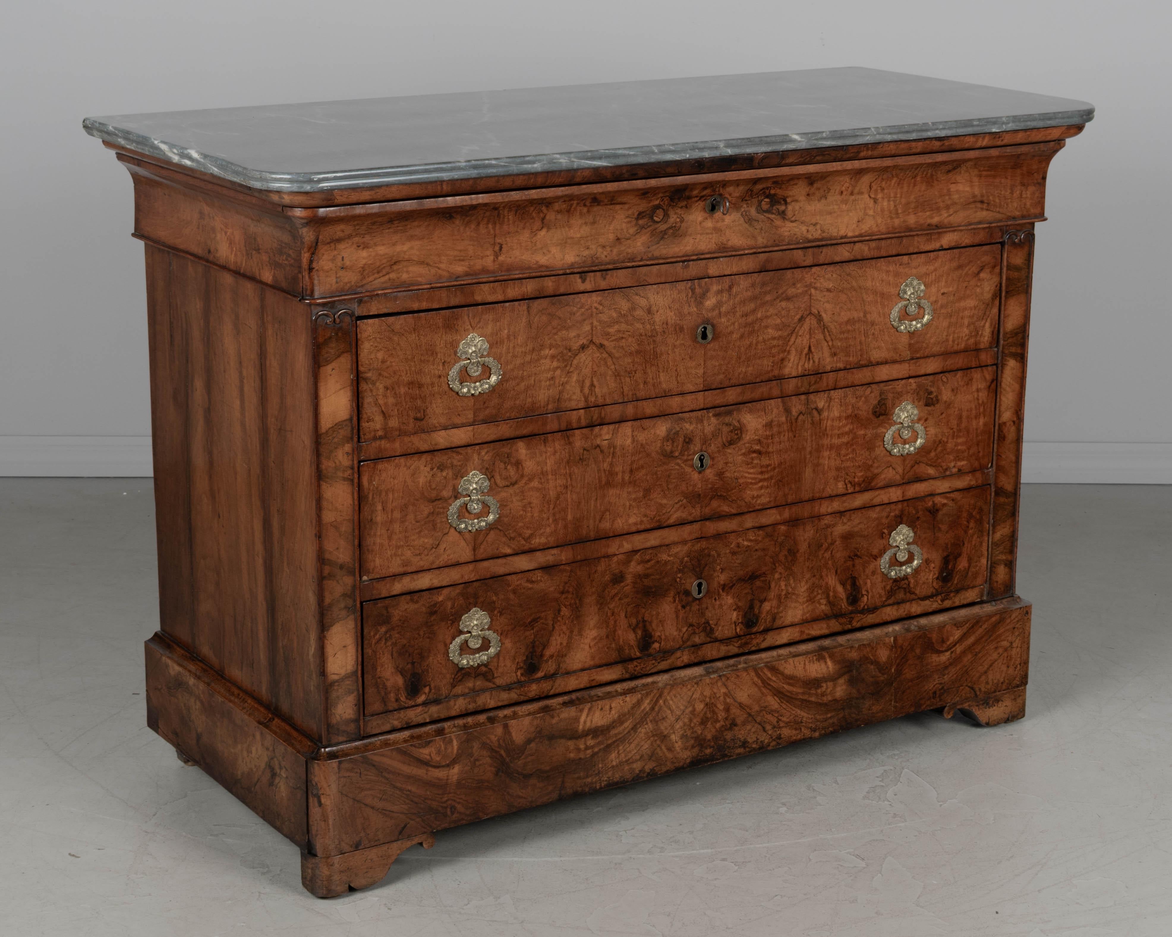 Una commode o cassettiera in noce con piano in marmo di Louis Philippe dell'inizio del XIX secolo. Lavorazione di pregio con impiallacciatura in noce abbinata al libro sulla faccia dei cassetti e fianchi in noce massiccio. Oak come legno secondario.