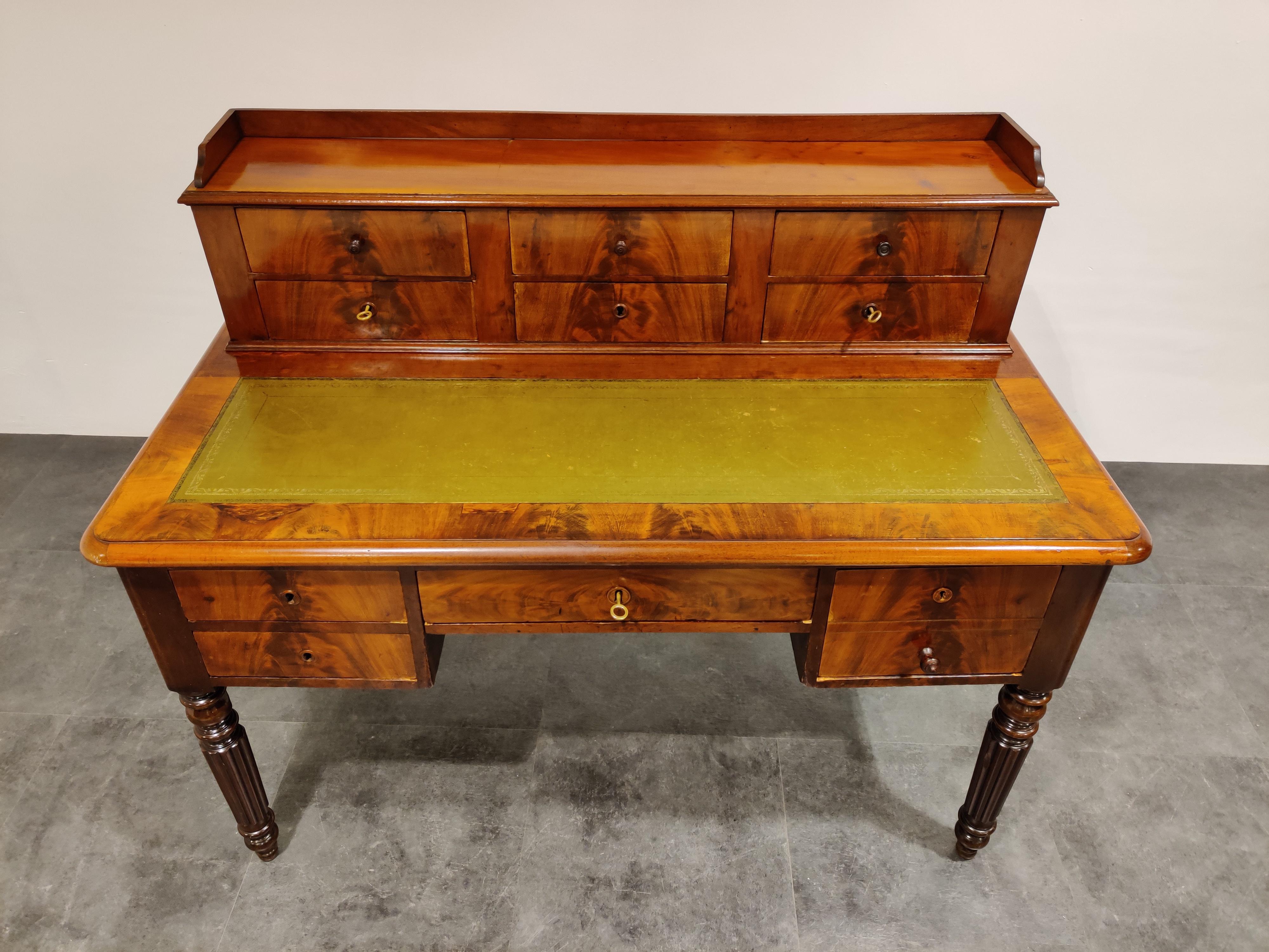 Elegant antique writing desk made from walnut wood and with a faux leather.

Very practical because of the many storage spaces and the deep drawers.

Beautiful veined wood.

Comes with working locks and keys.

Good condition, some minor age