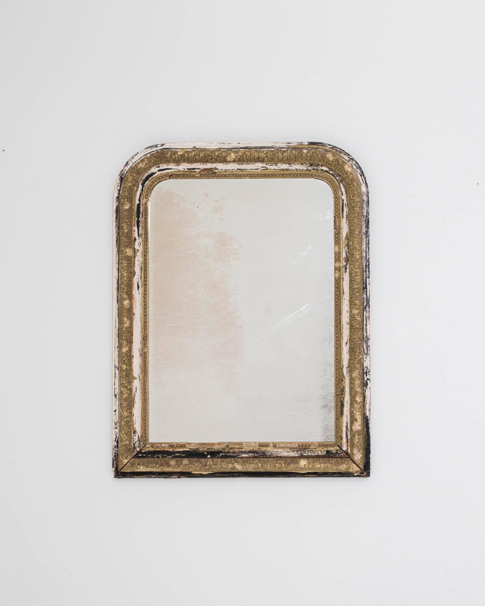 A giltwood mirror created in 19th century France. This one of a kind mirror combines traditional design with a timeless sensibility. The rich patina that coats its frame has slowly ebbed away, creating a collage of materials, colors, and time. The