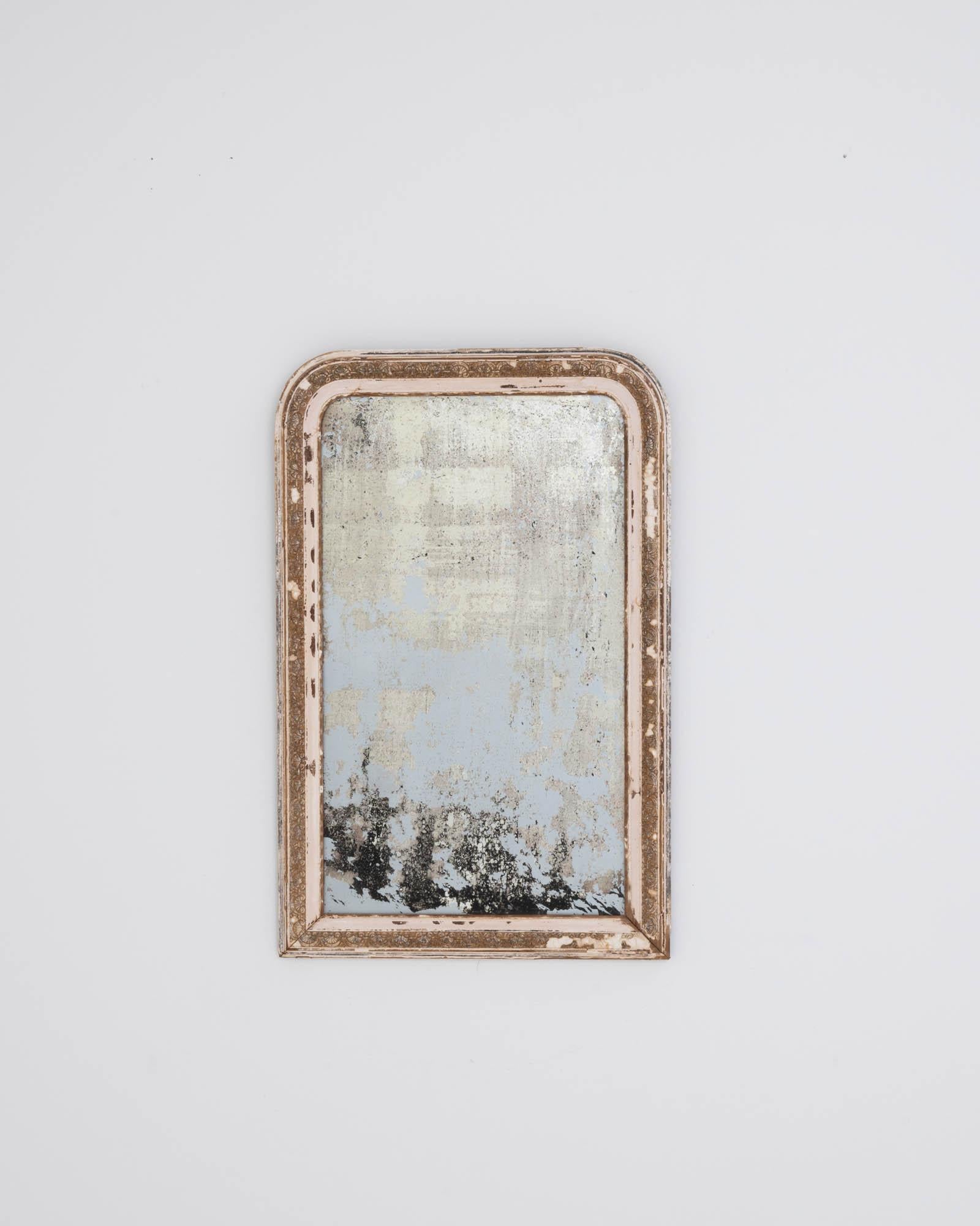 A wooden mirror created in 19th century France. Proudly aged, the paint has worn to a time touched patina, unveiling ochre hues, speckled with grey to shine a noble contrast on the arched frame. This one of a kind mirror combines traditional design