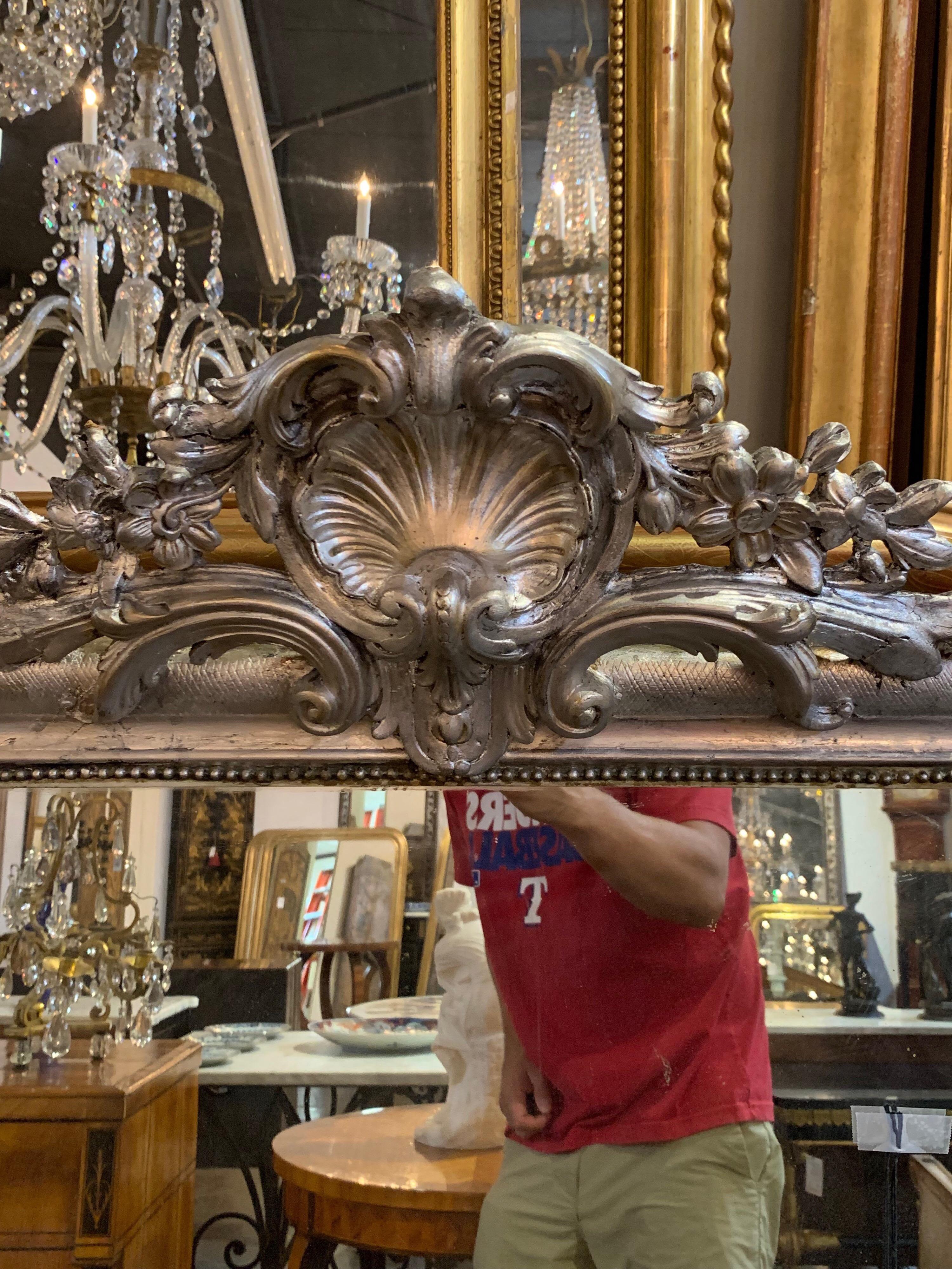 Beautiful 19th century silver Louis Phillipe mirror adorned with a crest. Very elegant for a fine home!