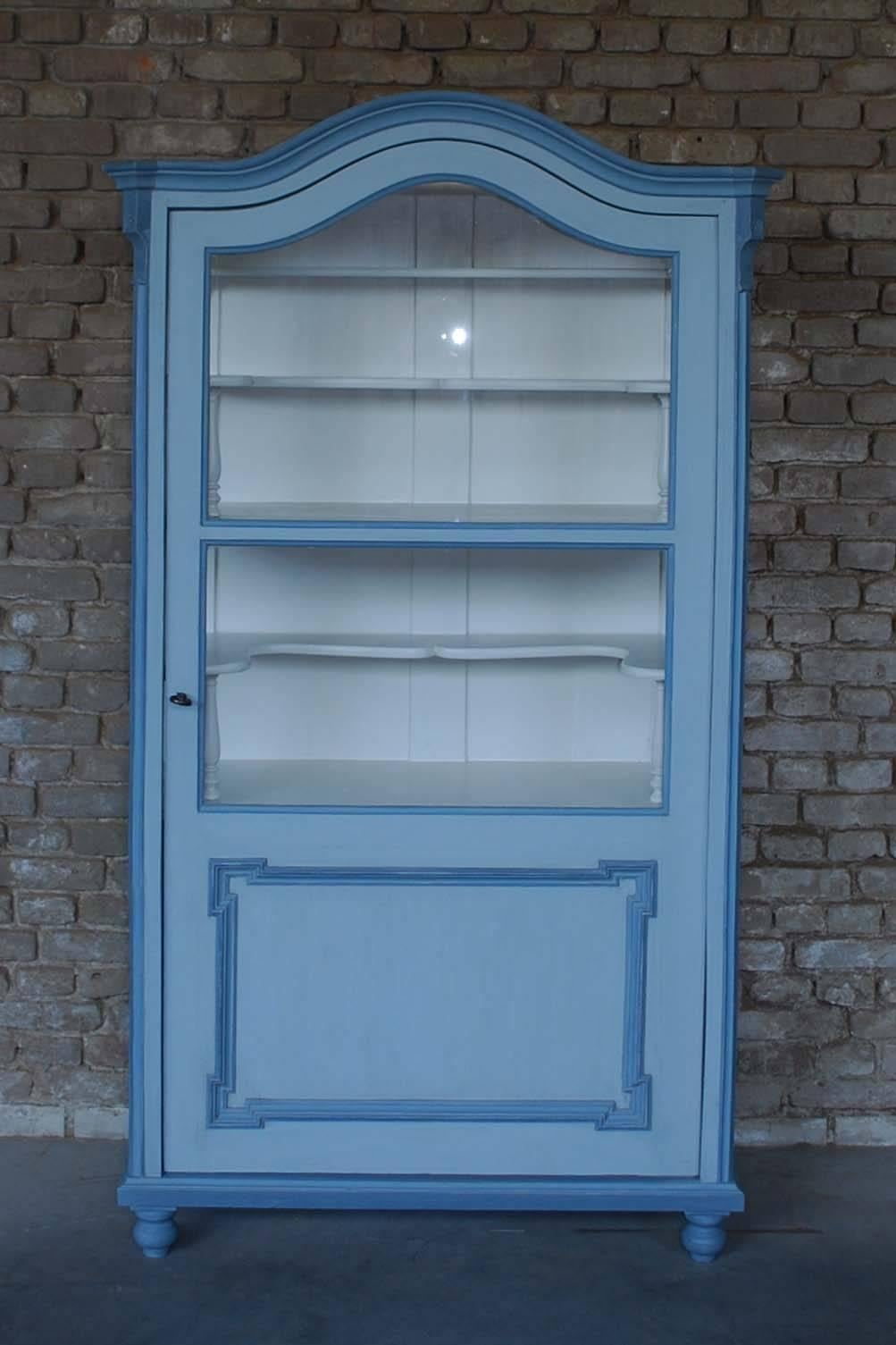 19th century French display cabinet or armoire in the Louis XV style.
This is an original display cabinet that is made in solid pine and veneer.
It has carefully been restored and painted in a light grey base color with blue highlights.
It has