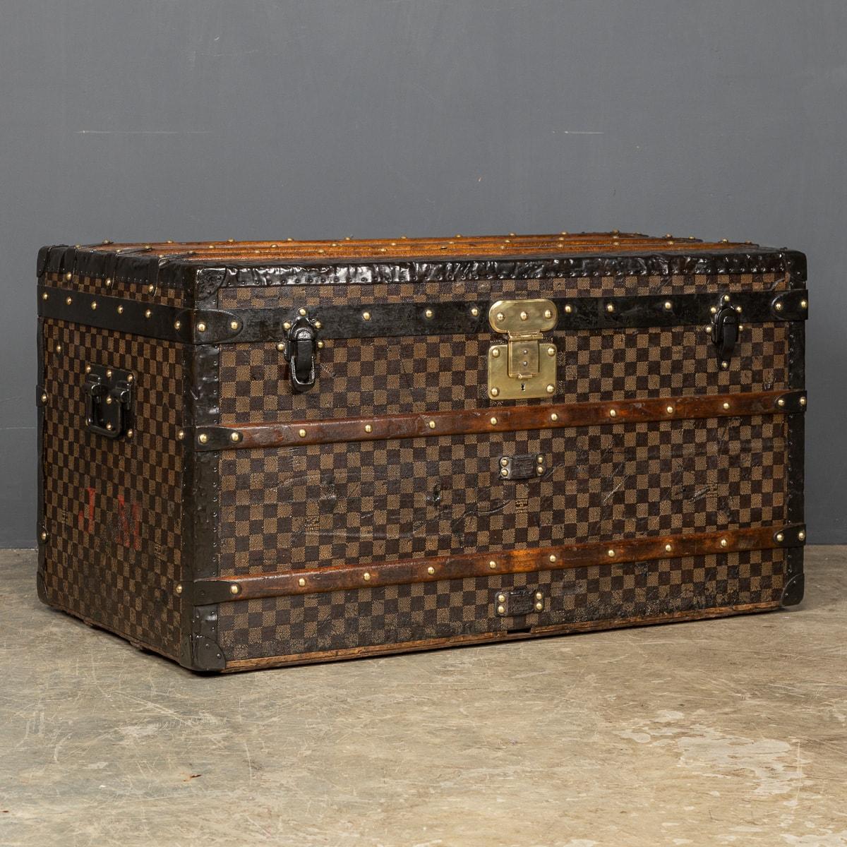 Antique 19th Century large Louis Vuitton Trunk in the traditional checkerboard canvas with red striped lining and two original trays. This trunk has metal edging and handles and a brass lock, c.1890. Around the turn of the 19th and 20th century