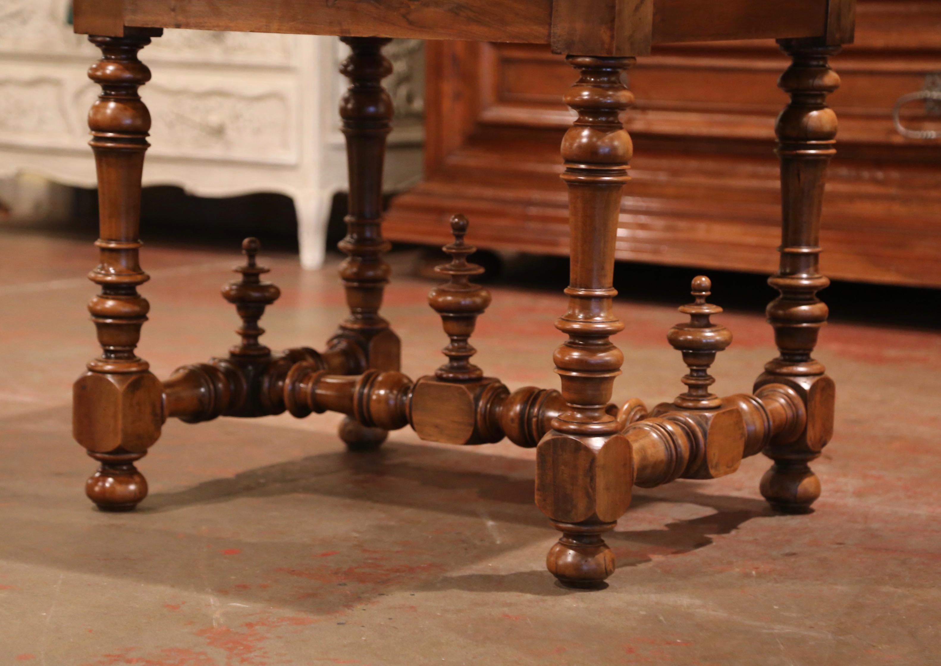 Incorporate extra, functional surface space into your living room with this elegant antique fruitwood writing table. Crafted in the Périgord region of France, circa 1860 and made of walnut and pear wood, the writing table sits on hand carved, turned