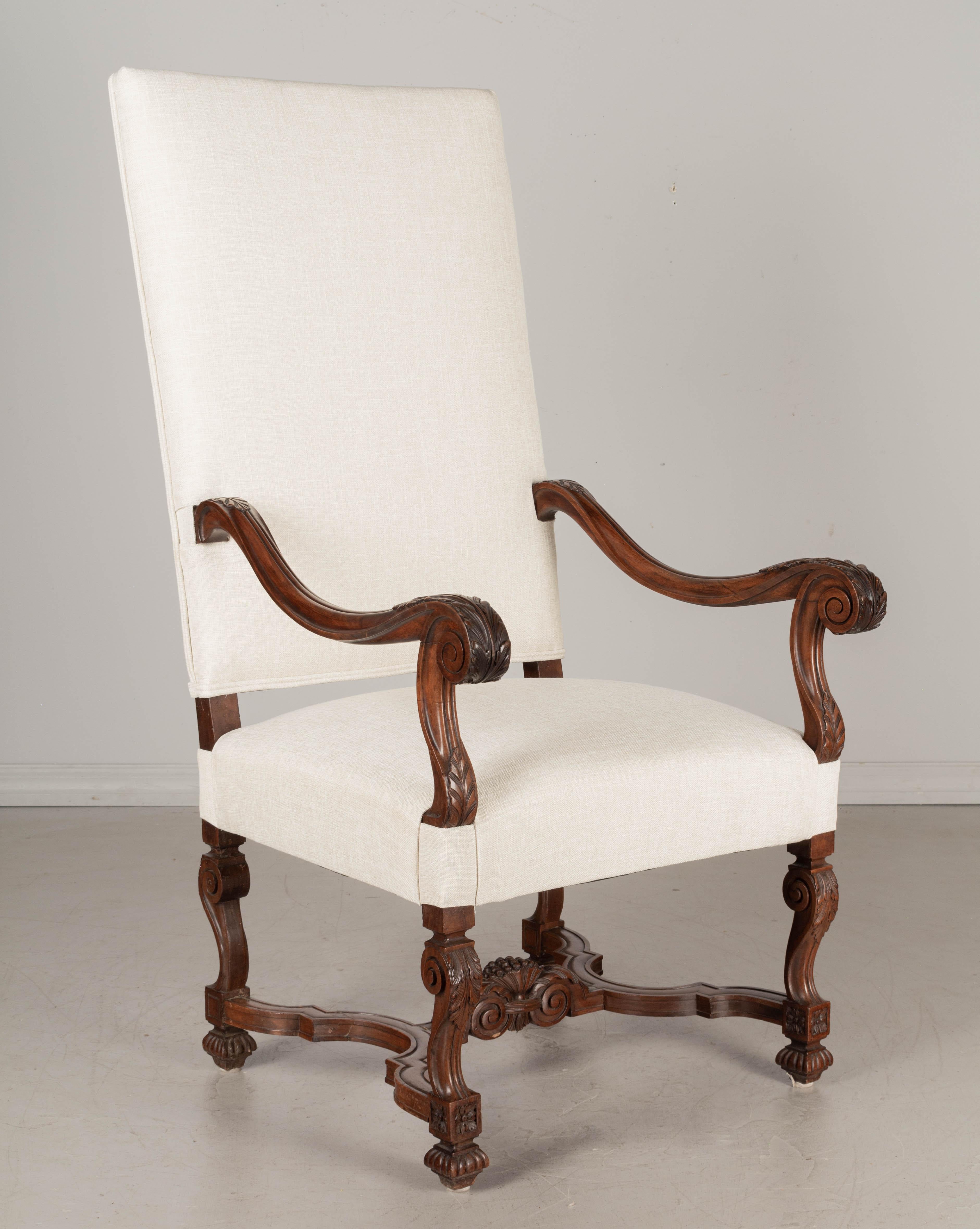 A 19th century Louis XIII style French fauteuil, or arm chair, made of solid walnut. Beautiful hand-carved details including sculptural scrolled arms and legs with acanthus leaves, and x-form stretcher with center decoration. Great quality frame.