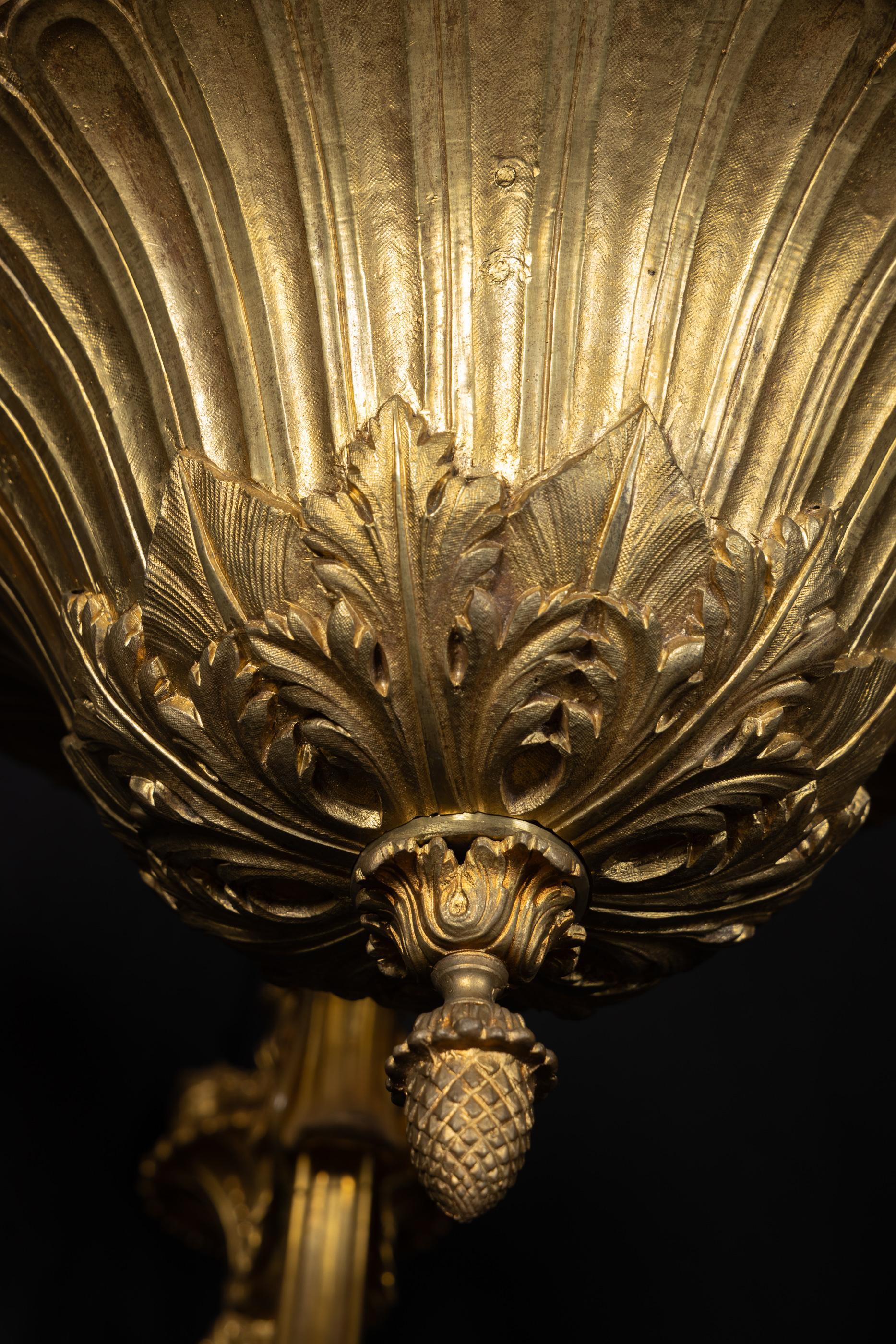 Questo imponente lampadario Luigi XIV è caratterizzato da uno squisito bronzo d'oro e da uno stelo incredibilmente dettagliato. Il pezzo del XIX secolo presenta delle tazze per candele d'ore, ciascuna incastonata in un bobeche finemente cesellato a