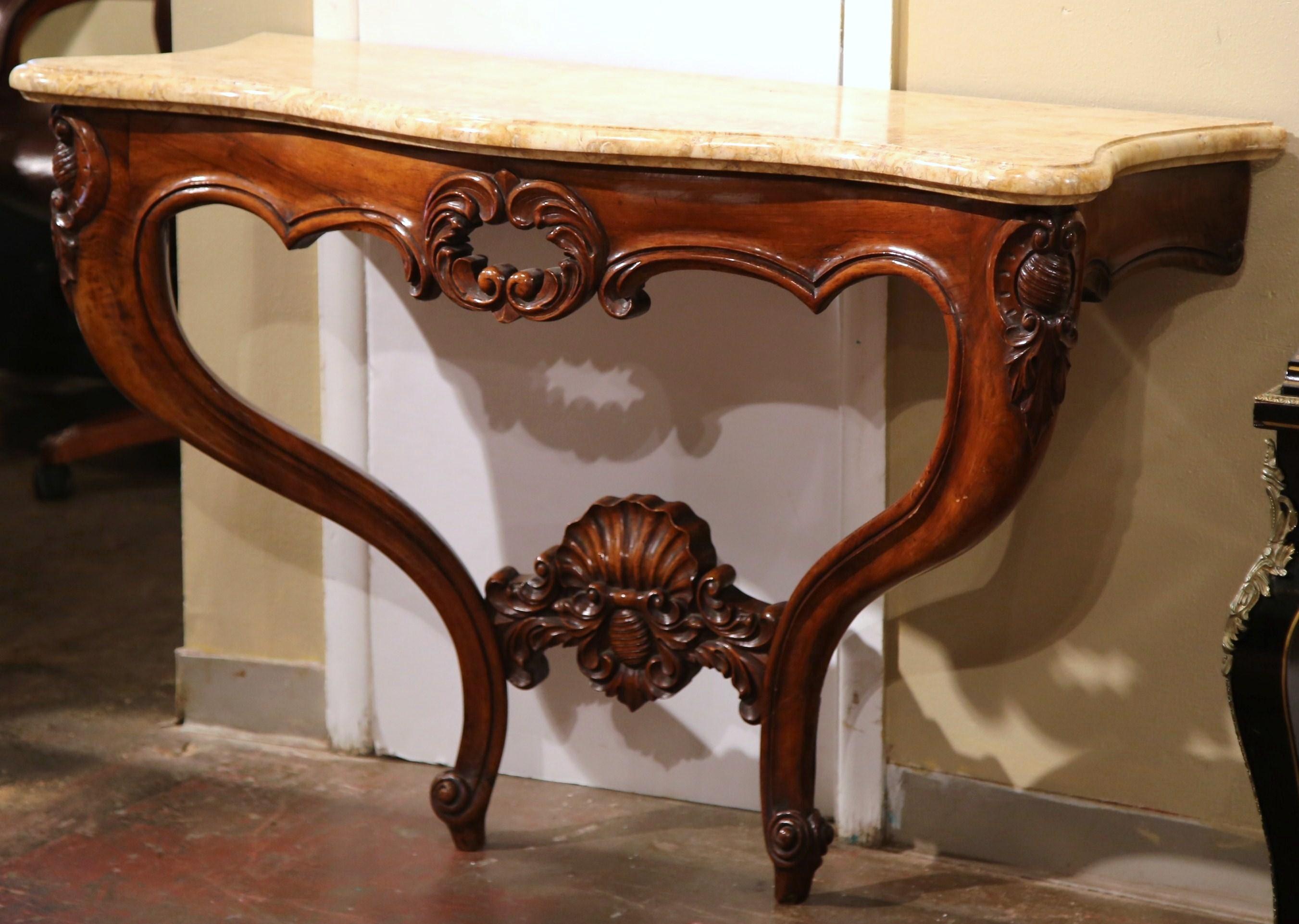 This elegant, two-leg serpentine wall console was crafted in Lyon, France, circa 1870. The antique fruitwood table stands on two front cabriole legs with hand carved motifs at the shoulder, and a bottom stretcher embellished with a hand carved shell
