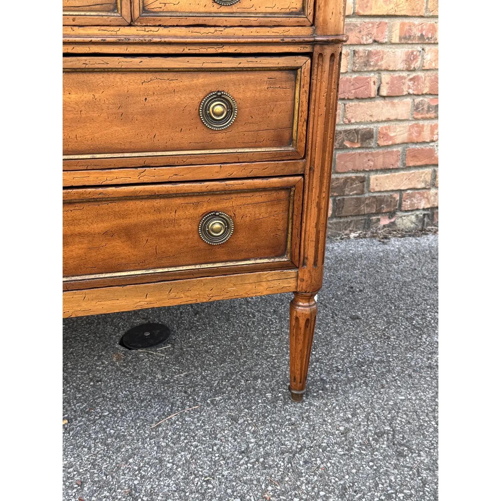 This is a beautiful early 20th century French chest of drawers! The wood is a gorgeous auburn tone with little ornamentation, but beautiful patina. The hardware dresses this piece up with the brass pulls, lovely key holes, and hand carved fluted