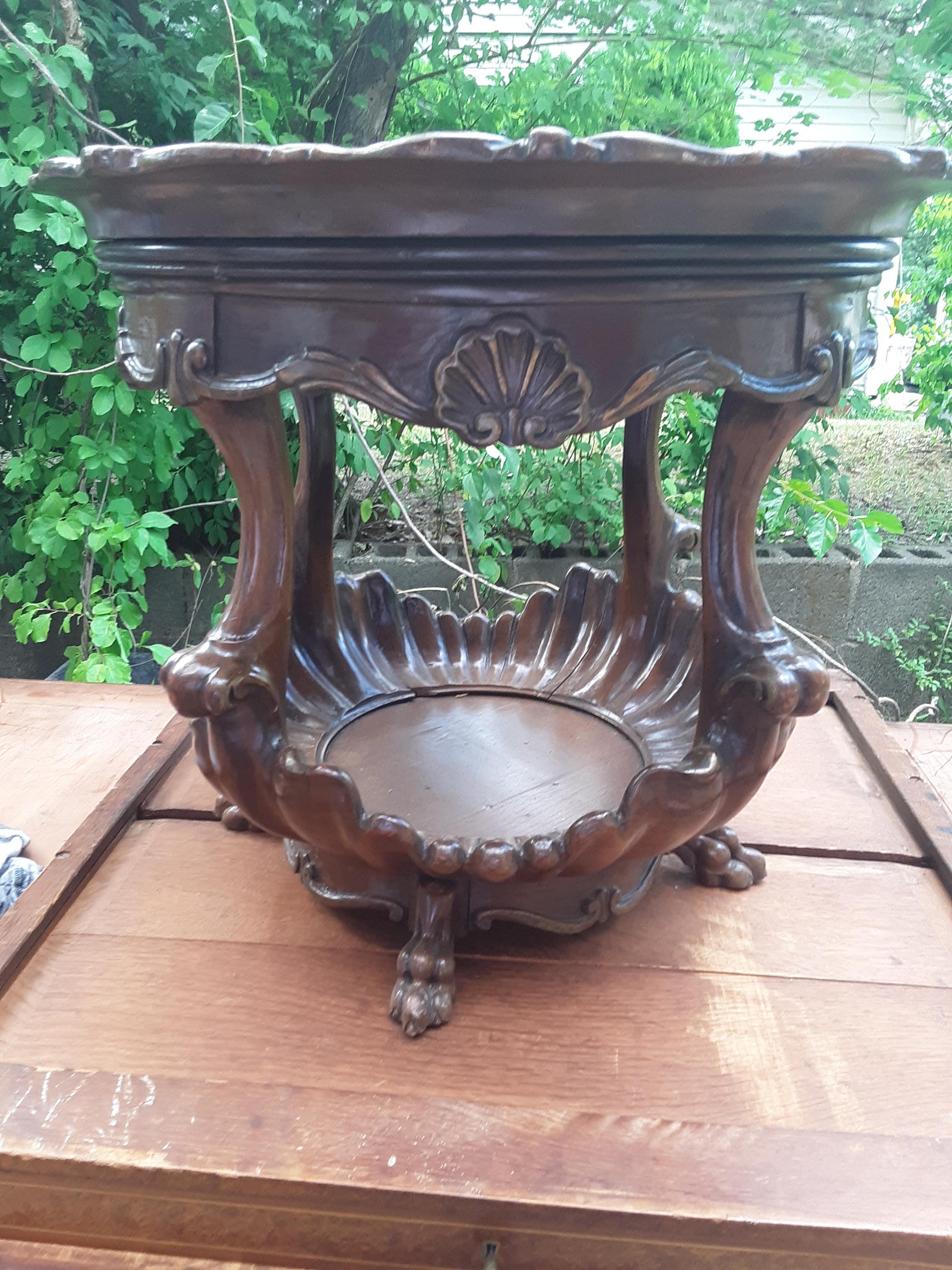 Beveled glass top, carved shell form lower shelf, satinwood floral inlay, beautiful wood grain, carved feet. This fine piece of antique furniture is comprised of a table top, which is supported on an ornate body, decorated with carvings of superb