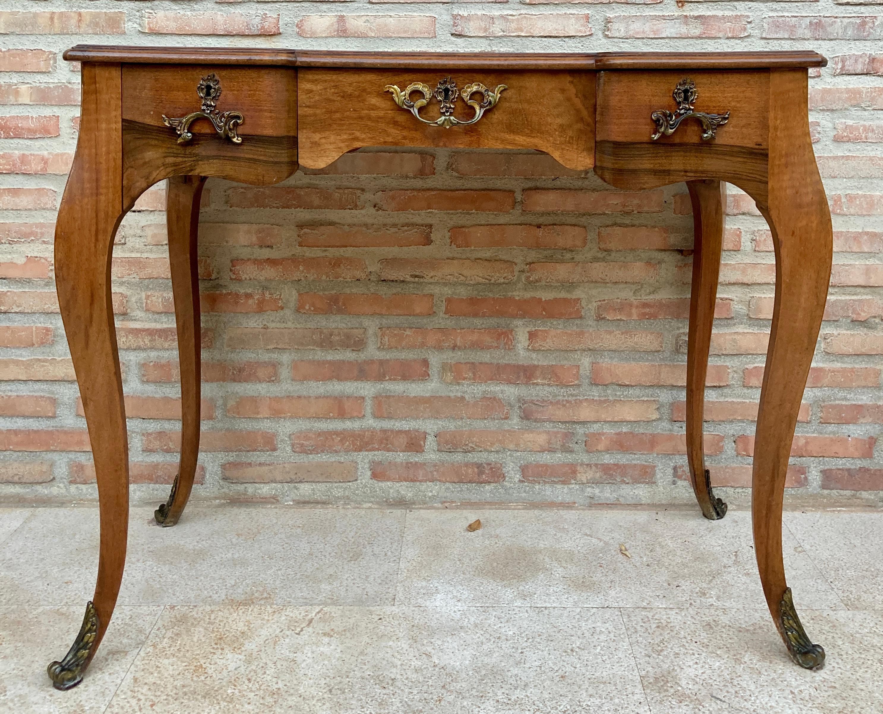 19th century Louis XV style French walnut writing desk with three drawers and cabriolet legs. Created in France during the 19th century, this walnut desk features a rectangular plank top above three drawers fitted with bronze pulls. Raised on four