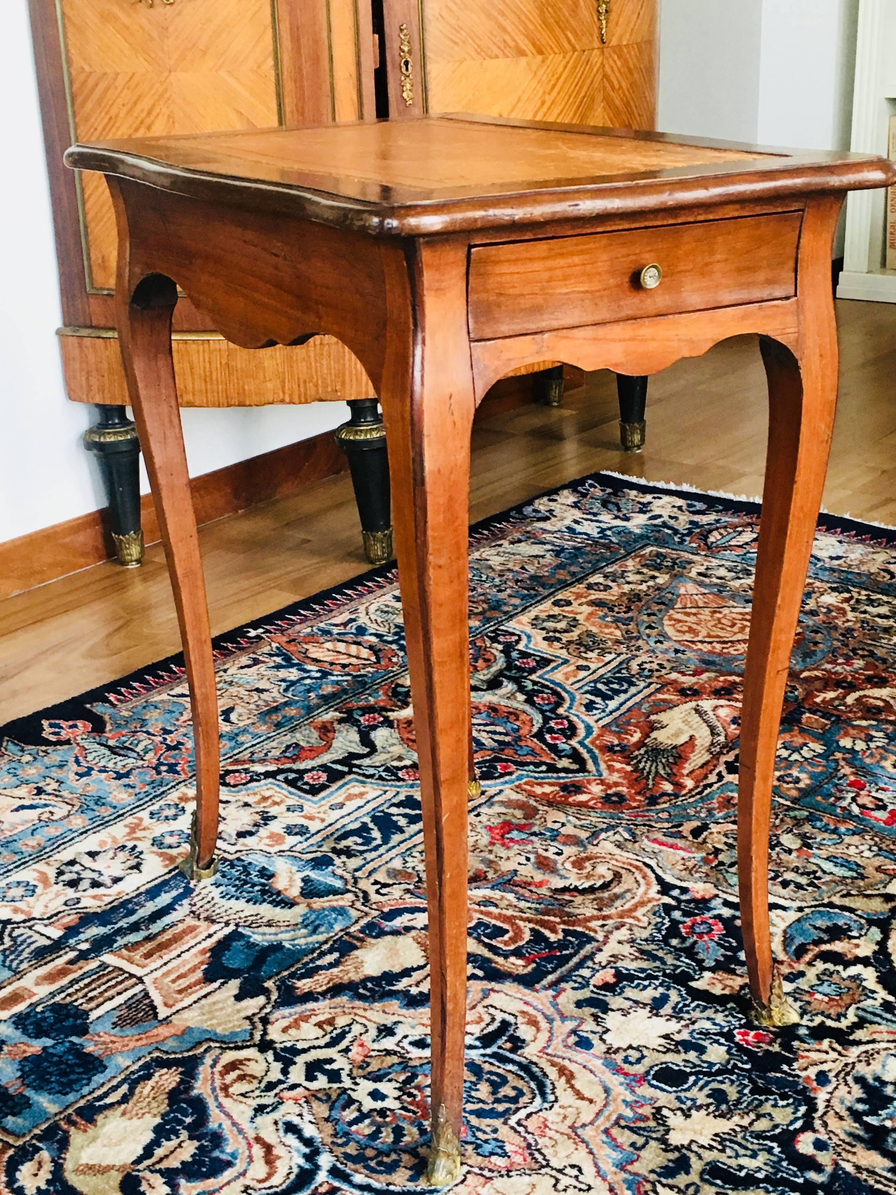 Petite et élégante table en bois naturel ouvrant à un tiroir latéral, l'épi découpé et les pieds cambrés. Dessus garni de cuir fauve
Louis XV, début du XIXe siècle.
