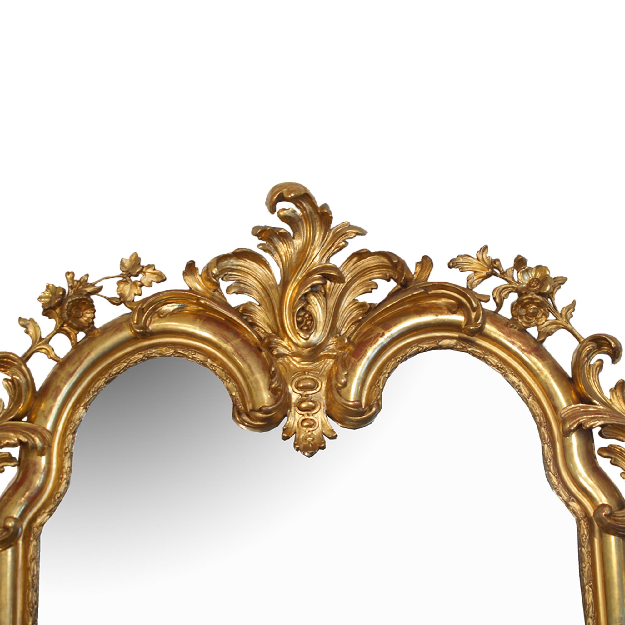 A very dynamic 19th century Louis XV giltwood mirror with original gilt and mirror plate. At the top and bottom large scrolling acanthus leaves amidst blossoming floral. The impressive top crown with a striking central acanthus leaves among scrolls