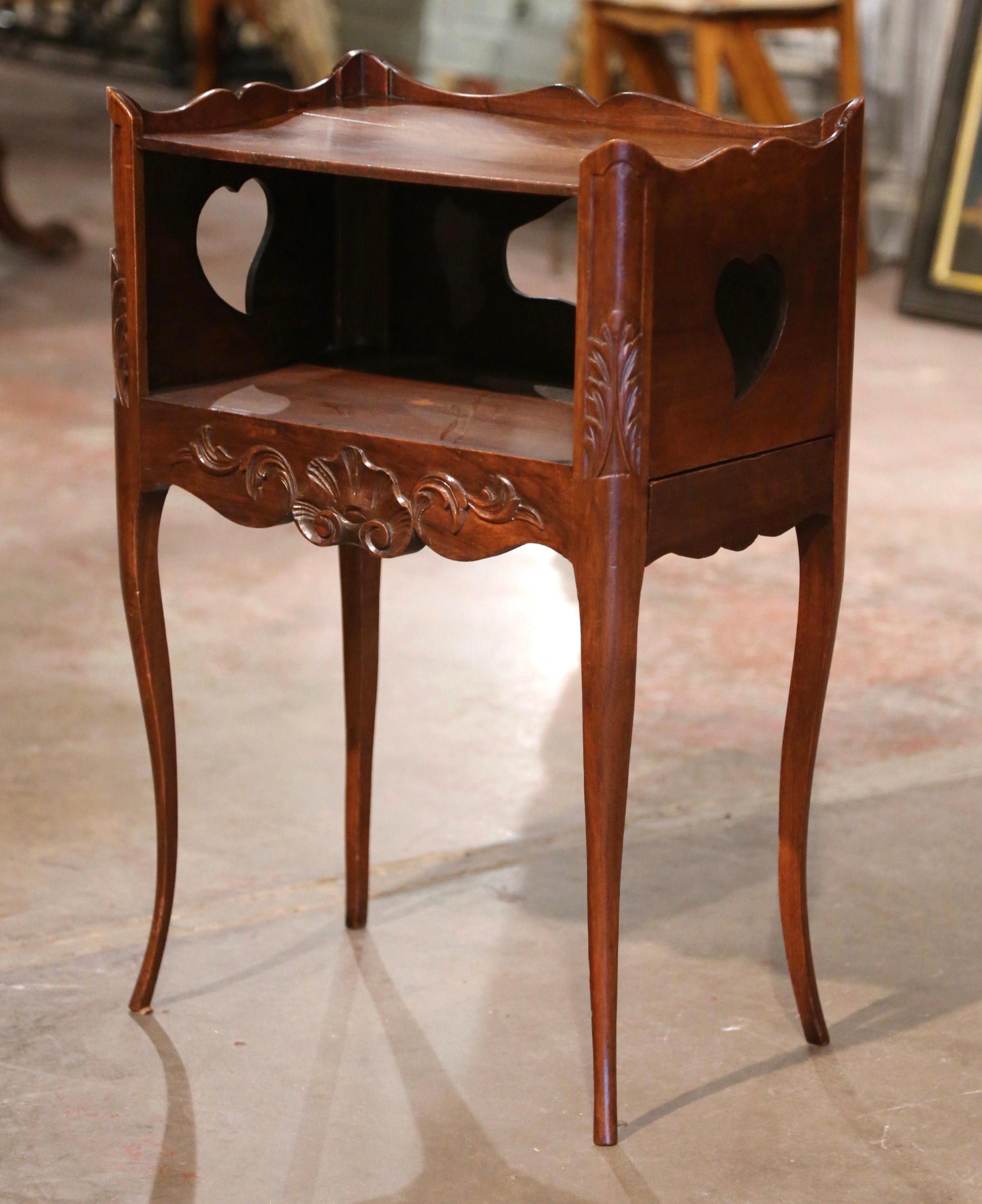 This elegant antique table was created in Provence, France, circa 1890. The fruitwood cabinet stands on cabriole legs decorated with acanthus leaf motifs at the shoulder, over a scalloped apron embellished with shell and floral decor. The table
