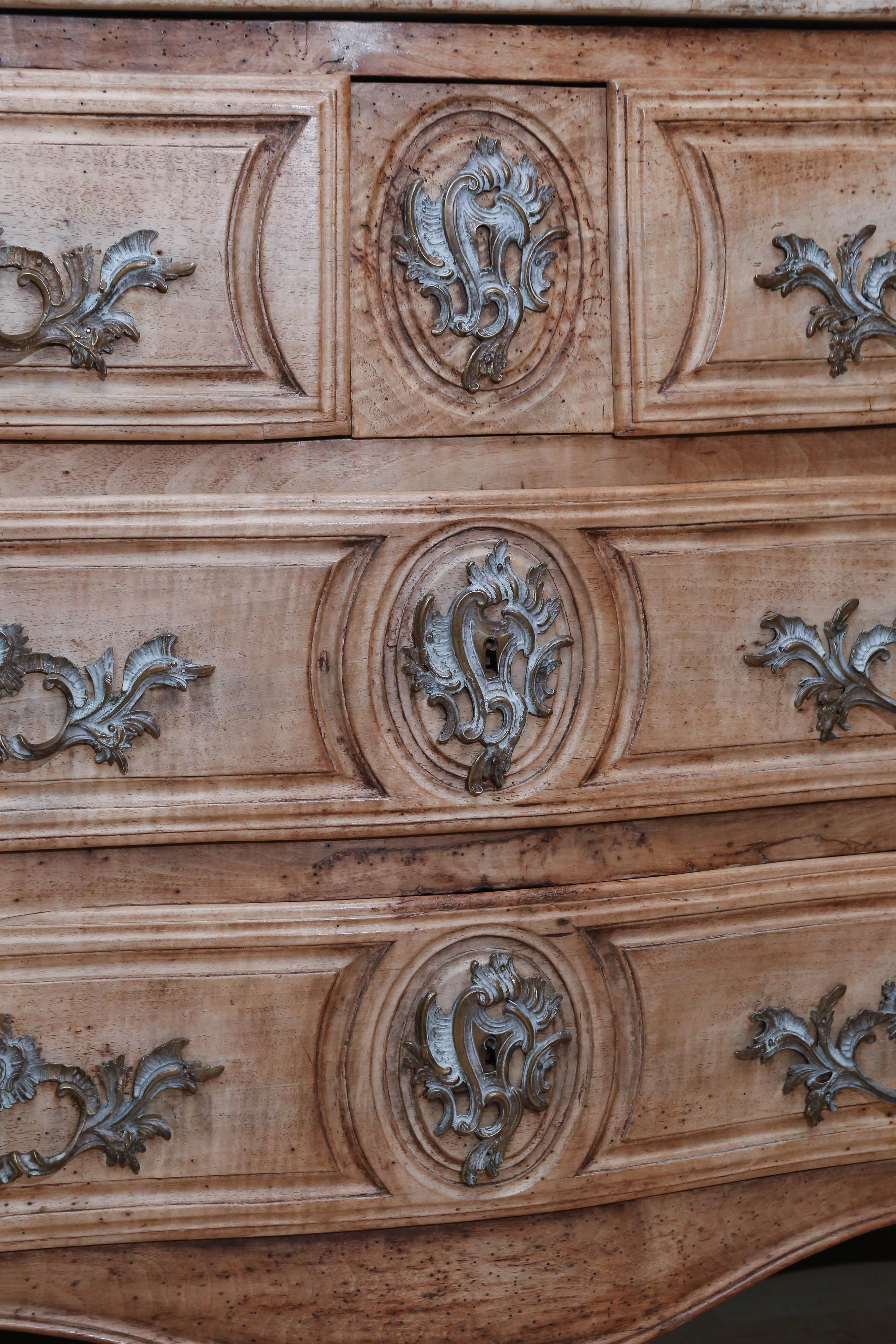 Walnut French three-drawer Louis XV chest with shaped marble top in neutral and greys.
Drawer fronts have three carved panels, each surrounding the hardware.
Sides also feature carved panels and front legs are cabriole.
Chest is adorned with