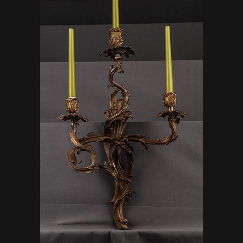 Antique original French wall application, circa 1850-1870.
Engraved bronze. Three-lighted luminary, flat wall sign made of relief volutes and acanthus leaves. In the middle of it extending three curved luminaries with an analogous leaf mechanism,