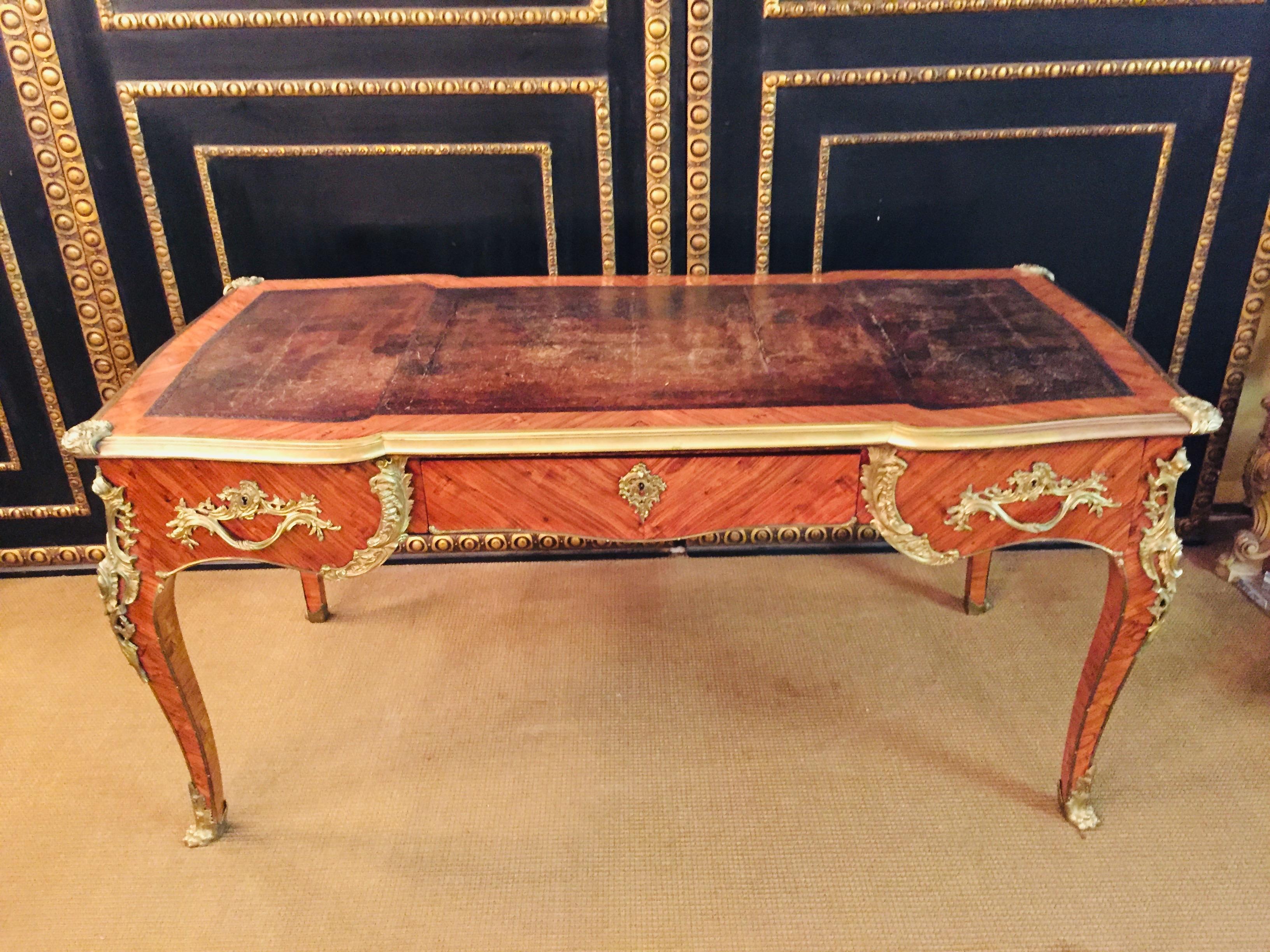 Bureau plat in the style of the Louis XV Napoleon III Paris, circa 1850-1880. In Bois-Satiné veneer, all-round full-length mirror veneer with seed beads. With very finely chiselled, highly decorative, restrained fire-gilt bronze fittings. Rosewood