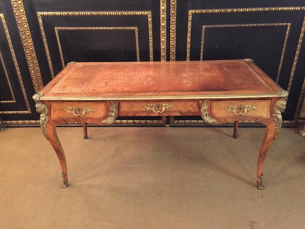 Castle worthy desk, solid wood. Rosewood veneer edged by finely engraved brass fittings. On angled, with four looking forward, imposing female busts on curly legs, on all sides scalloped, dreischübige frame with slightly recessed and elevated knee