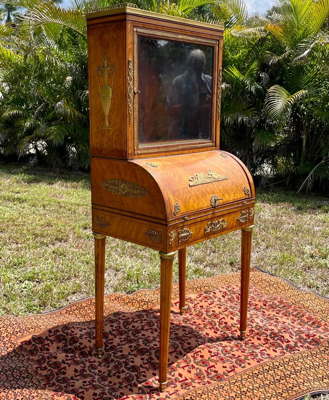 French 19th century Louis XV style Burlwood Ormolu Mounted Lady’s Desk.

Elegant French burlwood and ormolu mounted Lady’s cylinder desk. The single door cabinet is raised by slender fluted legs ending in bronze sabots. The upper glazed cupboard