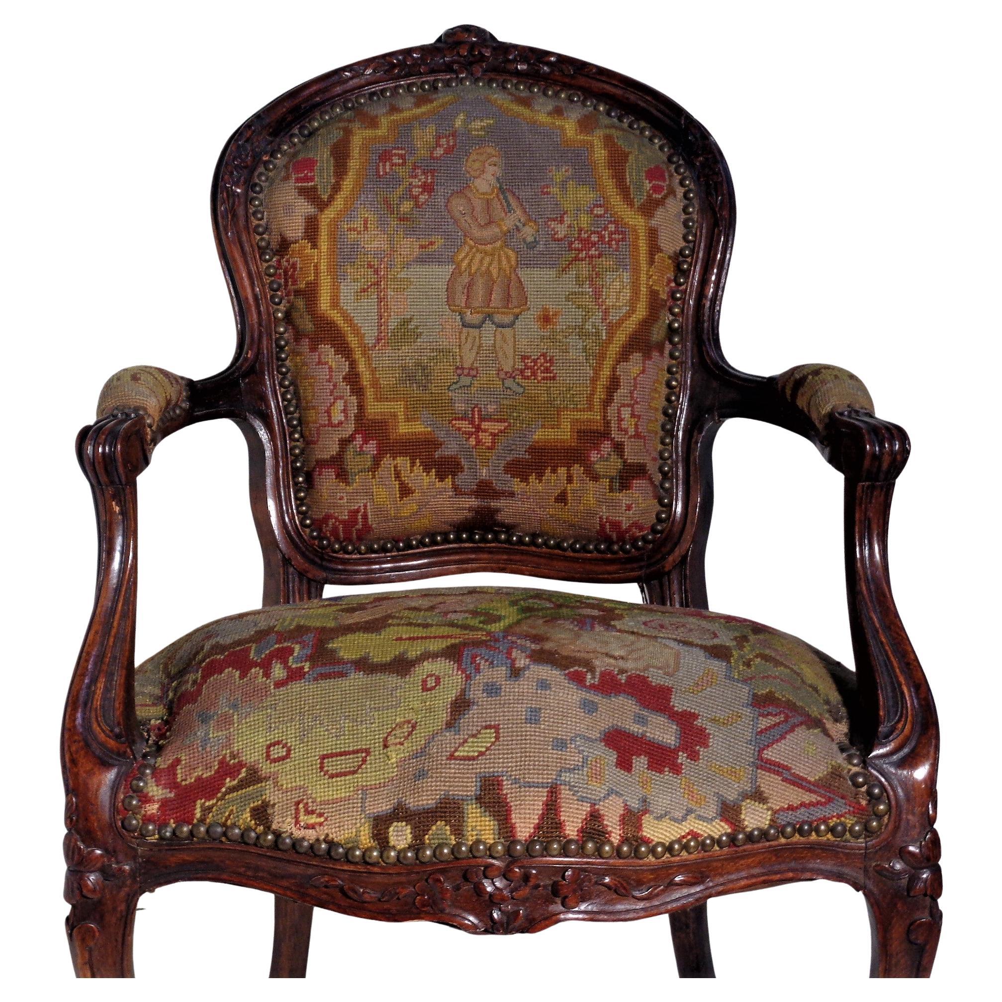 19th century French Louis XV style carved beech wood fauteuil covered in the original grospoint tapestry decorated w/ sheep, bird, figure in landscape, floral and fully surrounded brass nail head trim. Overall beautifully aged rich color. Circa
