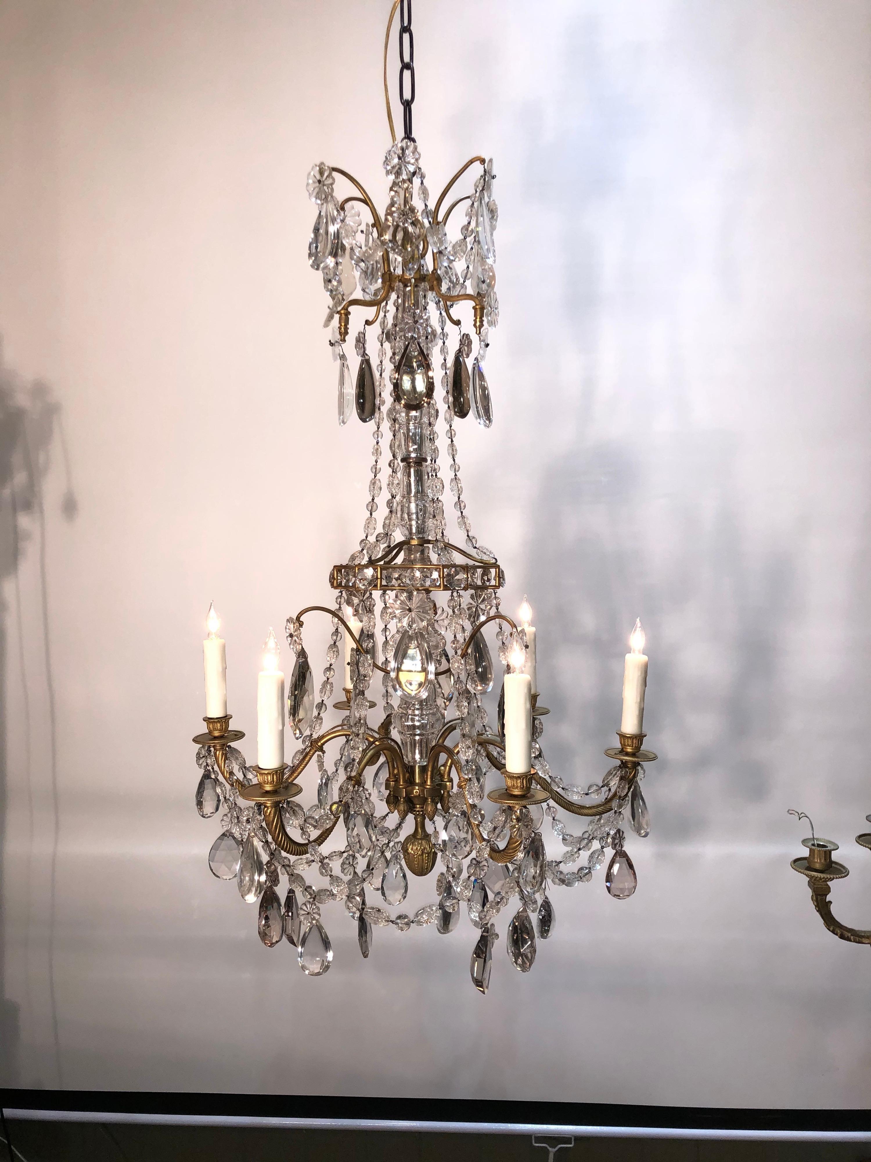Magnifique lustre français à 6 lumières du milieu du 19e siècle. Très beau lustre de style Louis XV en bronze doré et cristal. Colonne en cristal taillé facetté entourée d'un cadre ouvert en forme de cage d'oiseau en bronze doré. 6 branches, toutes