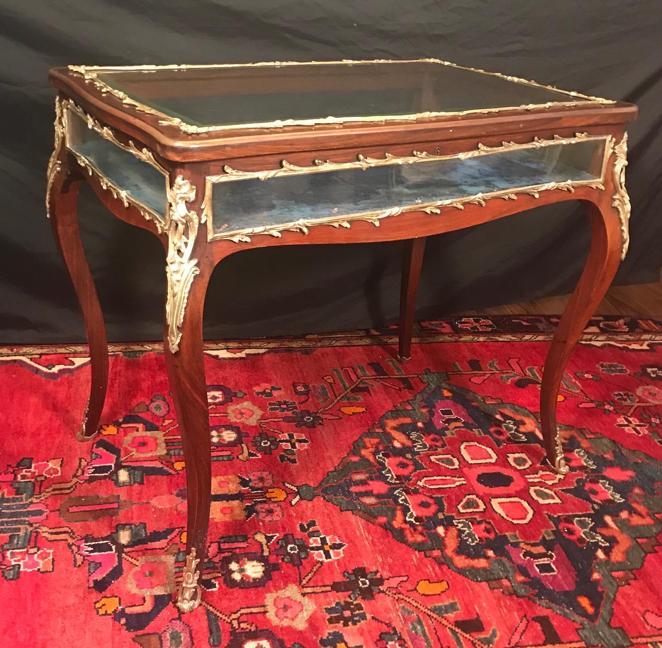 19th century Louis XV style curio display table, mahogany with bronze mounts

French Louis XV style elegant mahogany and bronze decorated display vitrine table. The table has four sided, curved and bent glass panels, which are trimmed with the