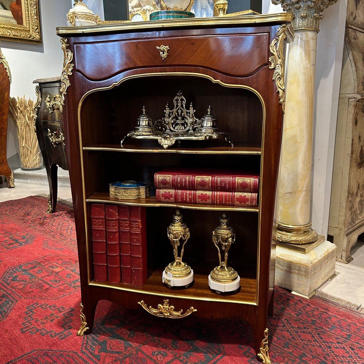 We present you this rare and charming 19th century, Louis XV-style small open bookcase, known as a 'bibus' in French. It has graceful curves on its front and sides and boasts a 'Brèche d'Alep' marble top, elegantly encircled by a gilded bronze