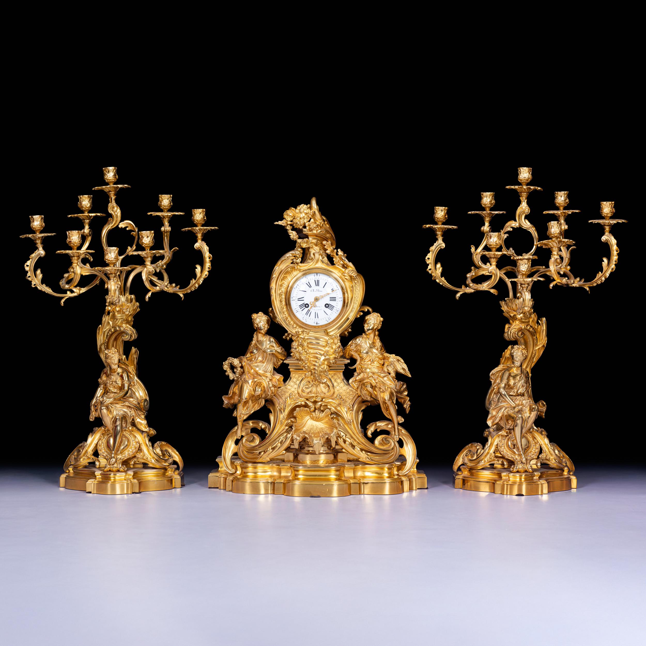 A stunning 19th century ormolu clock garniture in the Louis XV style by Ch. Drieu, the white enamel with Roman numerals signed “Ch. Drieu, 4 Rue de Thorigny”. The clock is flanked by two finely cast allegorical figures, possibly representing