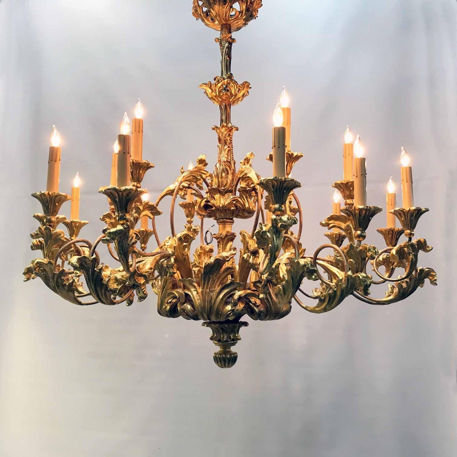 This sumptuous fixture has a pleasingly organic theme. It is essentially composed of elegantly shaped tubular arms, richly adorned with carved and gilded acanthus leaves. It is large and imposing but also has a naturalistic aspect. While probably