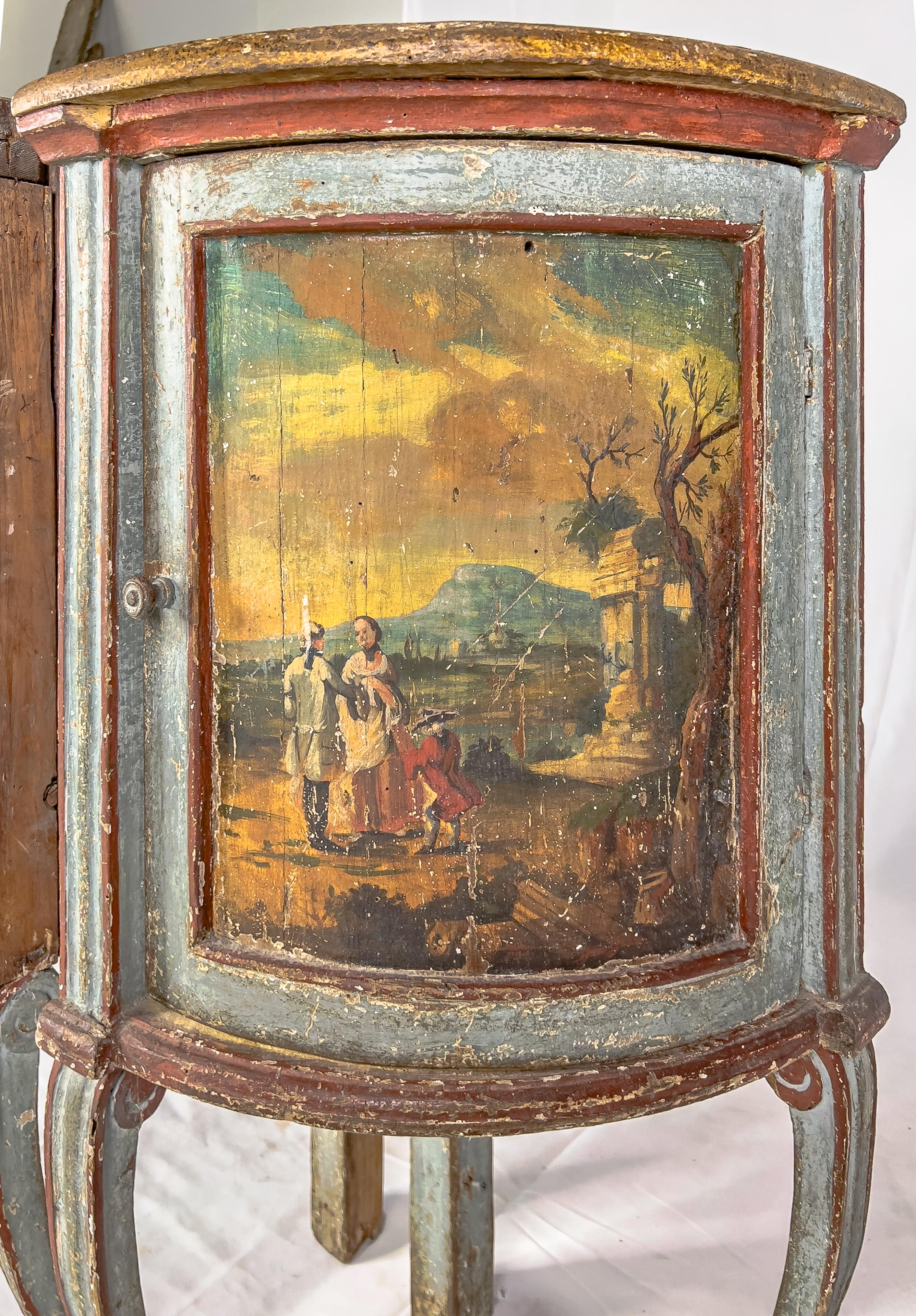 19th century Louis XV style hand-painted corner cabinets with cabriole legs. Each cabinet front has a painting depicting pastoral scenes with people and architectural ruins.