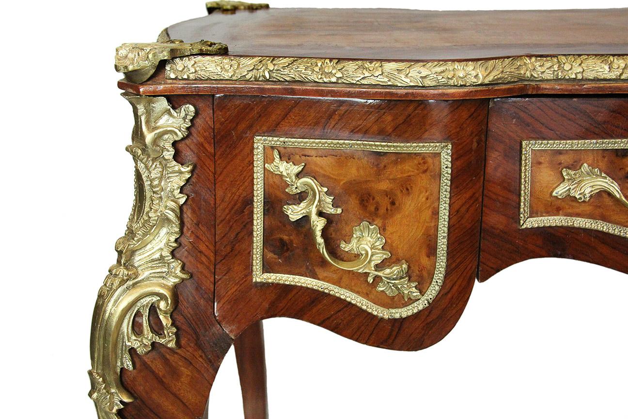 19th century Louis XV style lady's desk in rosewood and burl 
Superb lady's desk richly decorated with bronzes. Elegant work of veneer and marquetry in rosewood and burl (probably of amboyna) in reserves highlighted by a bronze fillet in the belt