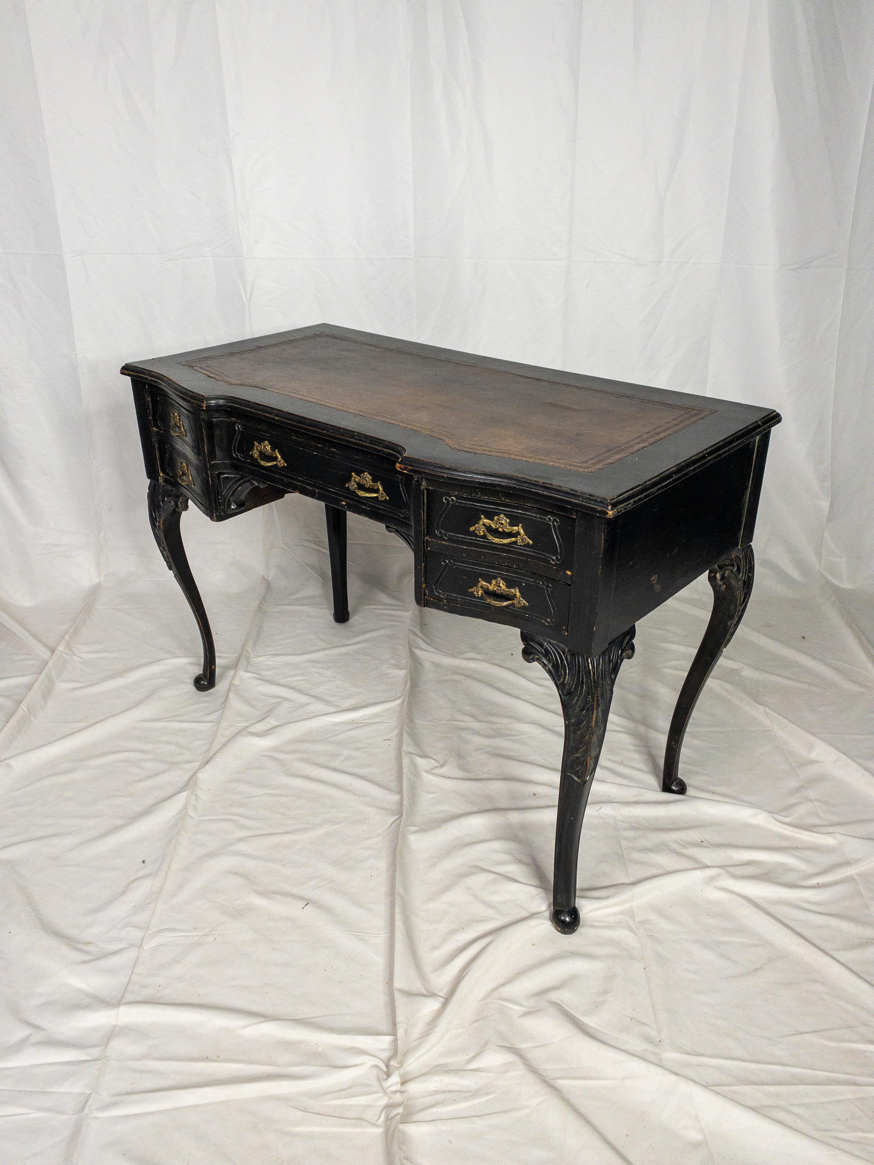 The 19th Century Louis XV Style Leather Top French Desk is a remarkable and ornate antique piece that exudes opulence and historical grandeur. Painted in a sophisticated black finish, it radiates a sense of timeless elegance, characteristic of the