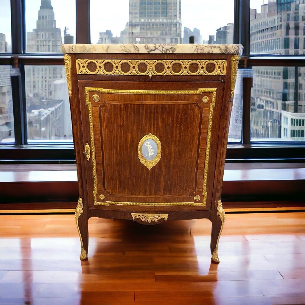 We present you with this exquisite sideboard, representing the Transition style of Louis XV and hailing from the opulent era of Napoleon III in the 19th century. It is adorned with marquetry and opens with a single door and a drawer. Its sides,