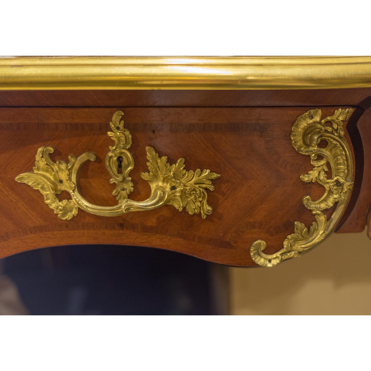 A fabulous quality 19th century ormolu-mounted bureau by Maison Krieger.
Serpentine top with brown leather writing surface, the frieze set with three drawers, the reverse with false drawers, the interior of one drawer with plaquette engraved