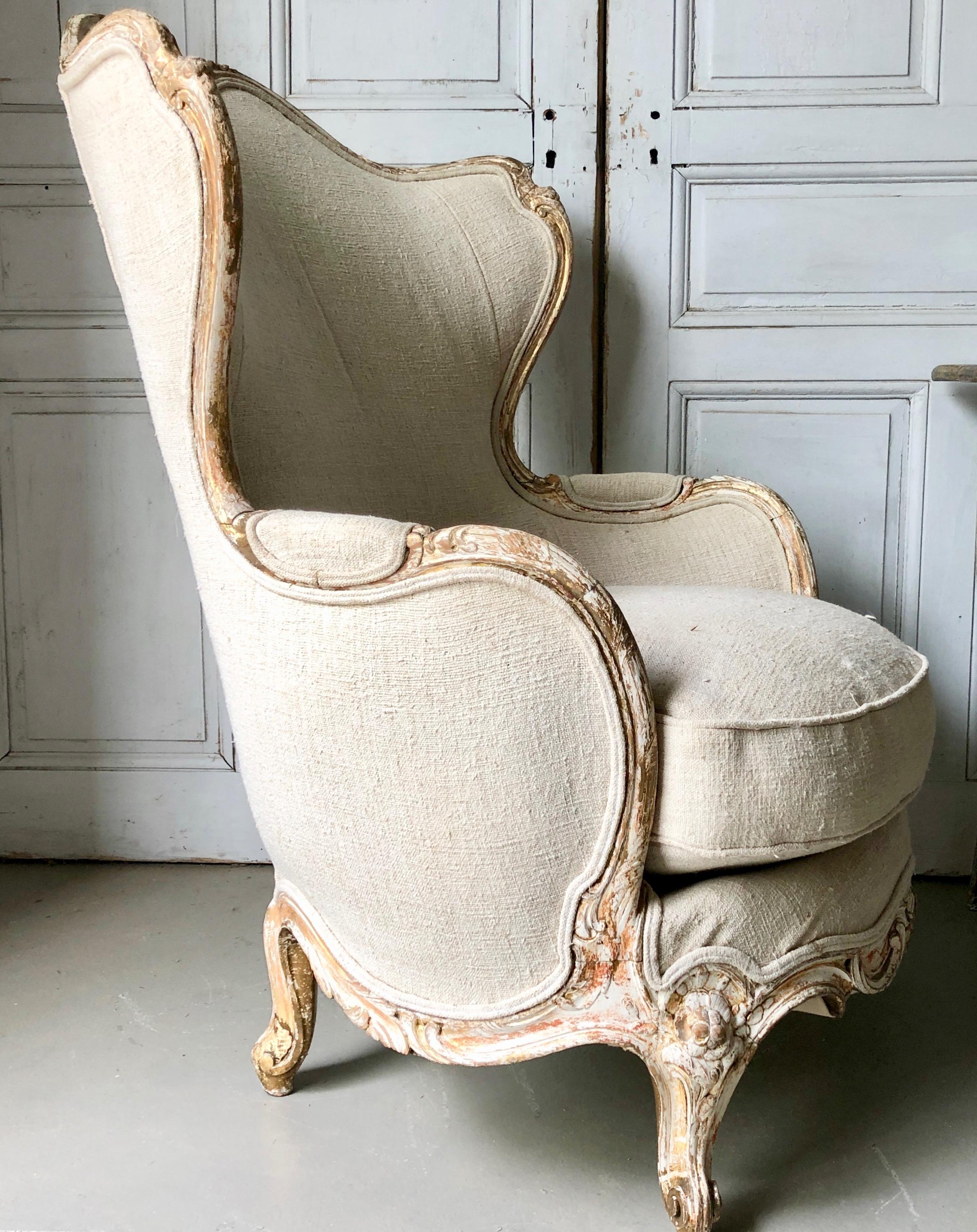 19th century French very wide and rare Bergère, Louis XV style with coved back which sweep without a break in to the armrests. Richly carved back and seat rails on elegant cabriole legs with flower carvings. Upholstered beautifully in hand spun
