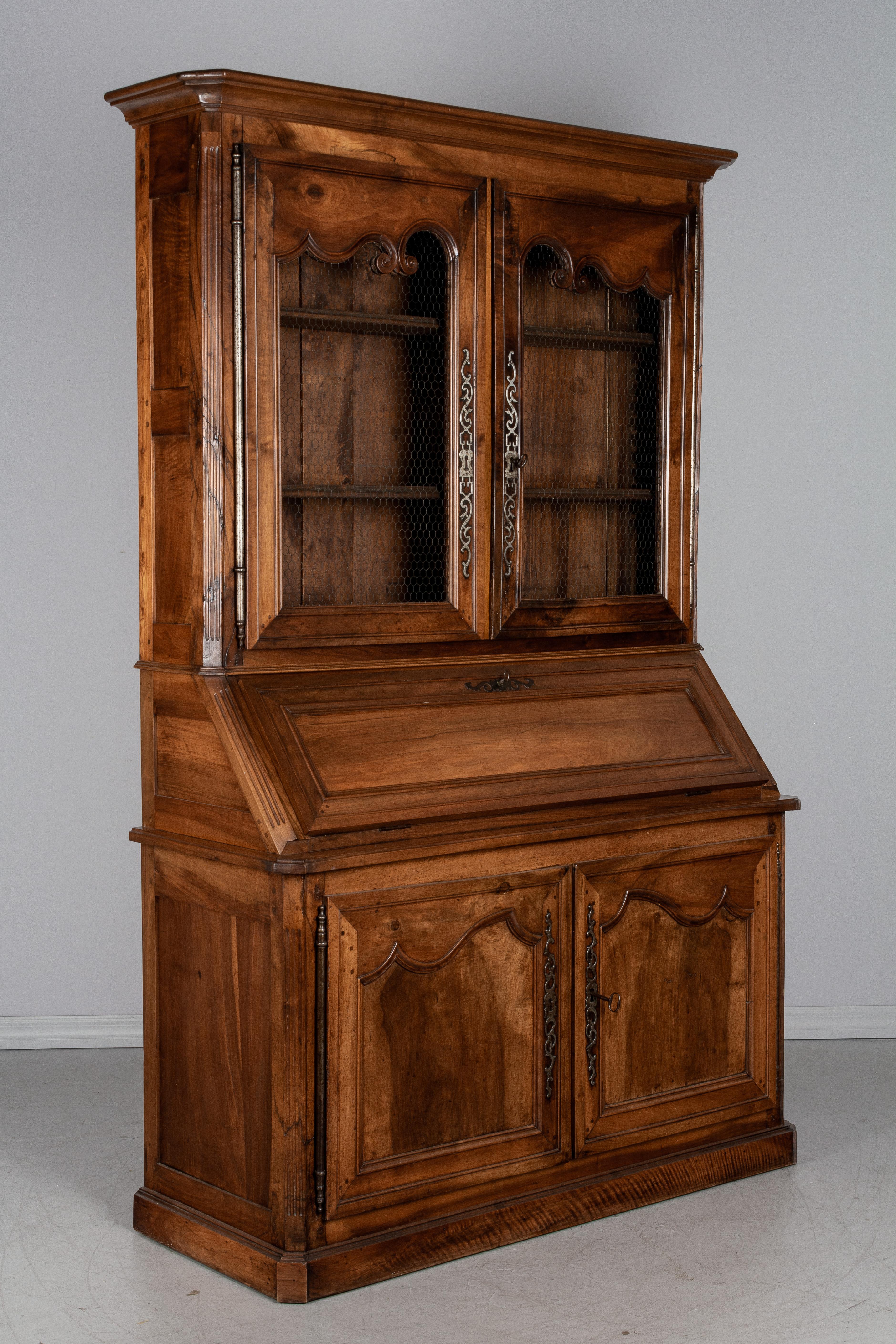 An exceptional 19th century French Louis XV style scriban, or secretary, from the Loire Valley, made of solid walnut with pegged construction and mortise and tenon joints. The abbattant, or slant front desk, hinges open to reveal a leather writing