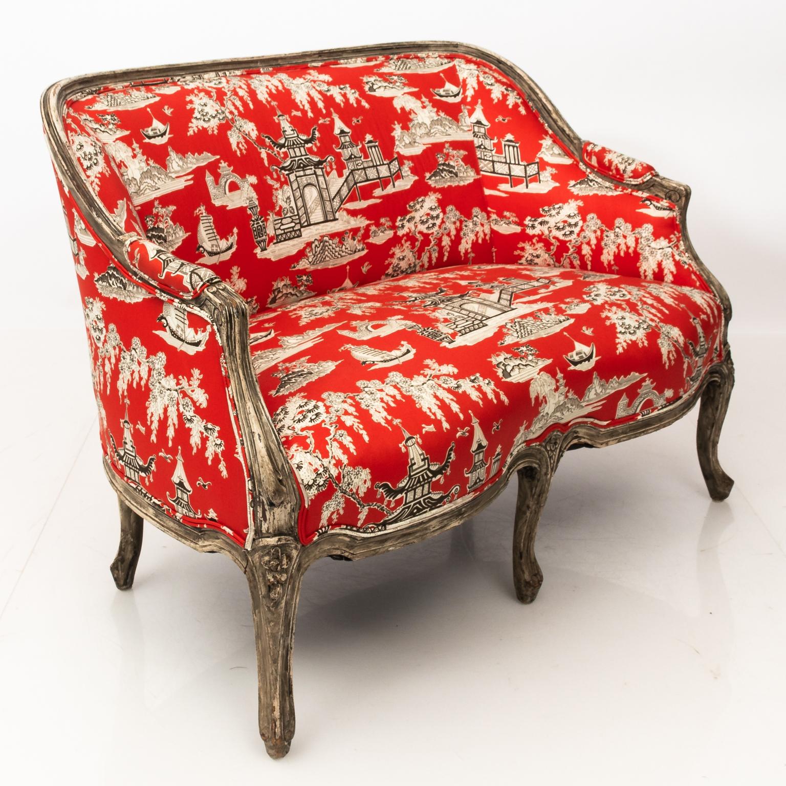 Louis XVI style French settee newly upholstered in chinoiserie red fabric. Berger style frame resting on a six legged support with scrolled arms and cabriole legs.
     