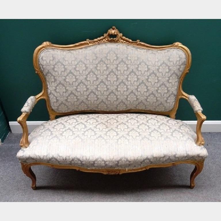 A 19th century Louis XV style carved giltwood seven-piece salon suite, the settee and chairs carved with foliage and upholstered in pale blue and raised on cabriole legs
Sofa 135cm wide x 109cm high, 
Armchairs 66cm wide x 99cm high,
Four single