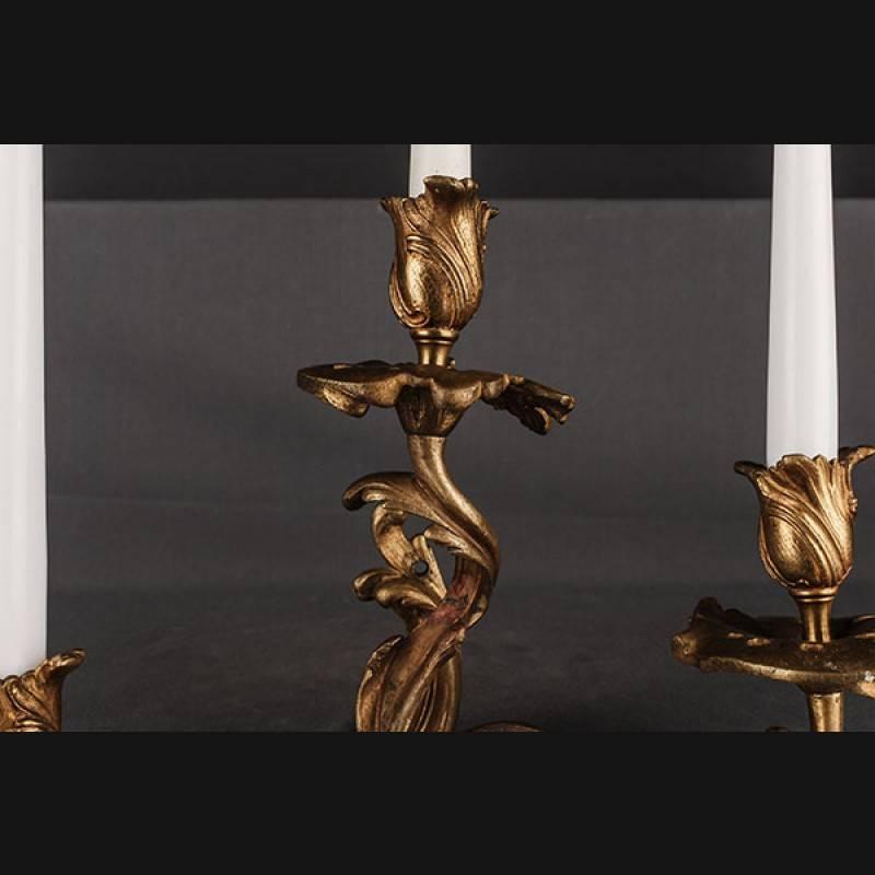 Original antique Rococo wall light, circa 1890.
Chased bronze. Three-lighted luminary, flat wall sign made of relief volutes and acanthus leaves. In the middle of it extending three curved luminaries with an analogous leaf mechanism, in vase-shaped