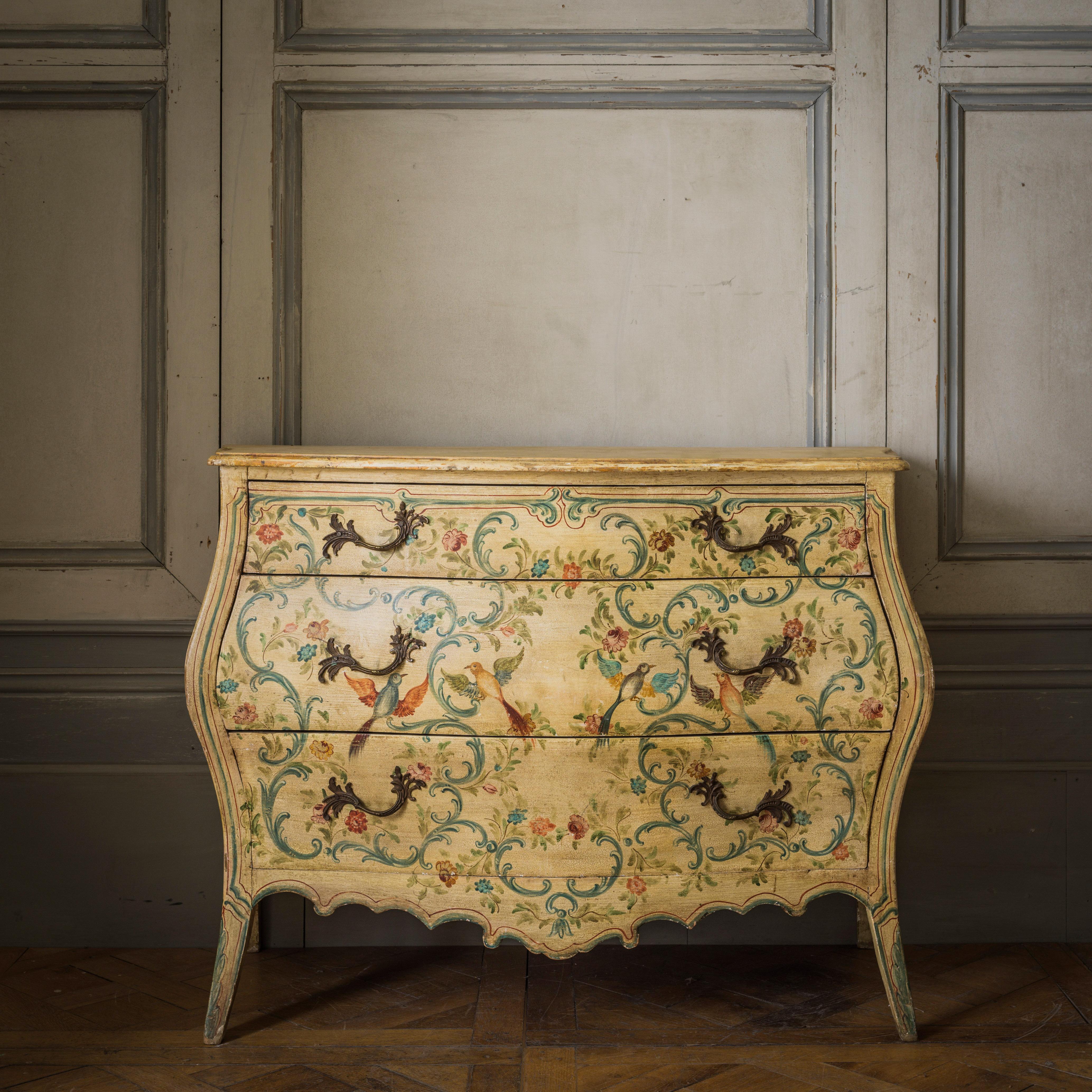 A late 19th century Venetian painted, bombe shaped chest with beveled top. The chest features finely hand painted Venetian work with depictions of stylised Rococo 's' curves, flowers and fanciful birds, all in tones of red, green and blue on a